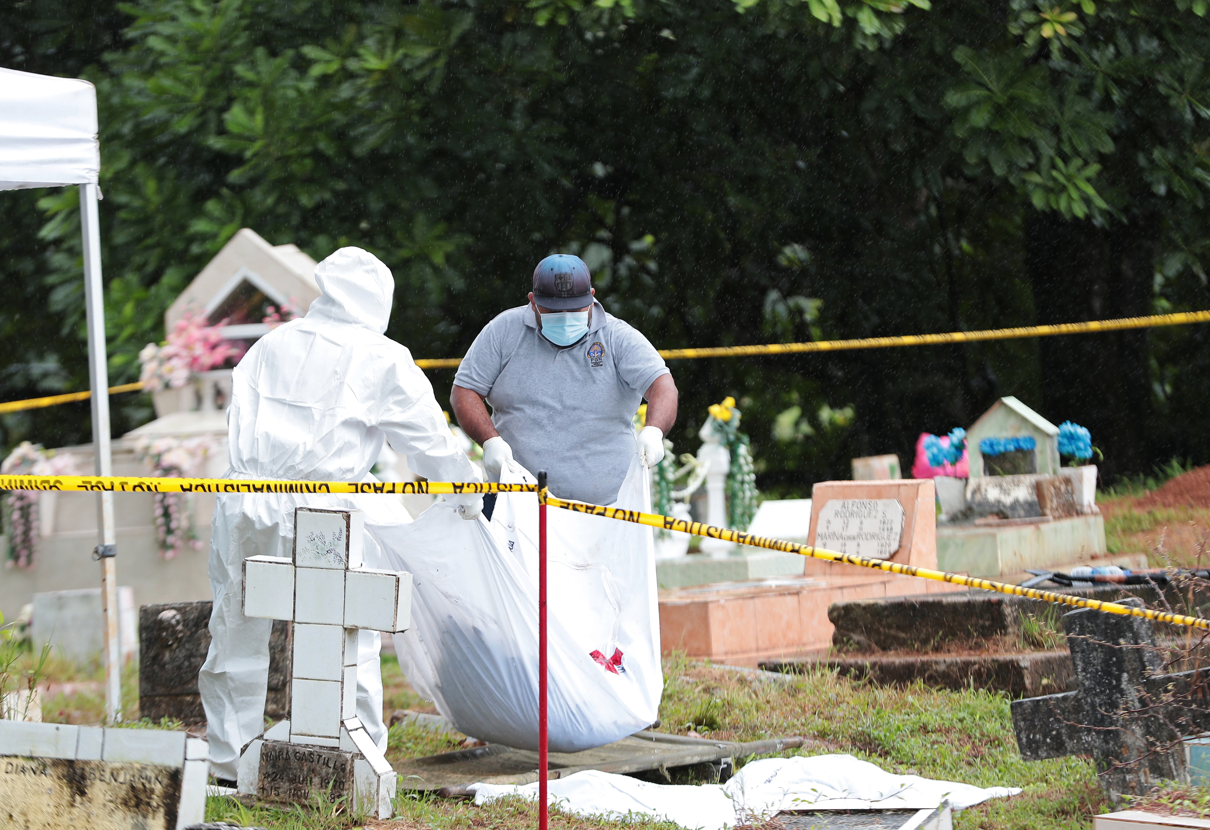 Members of a forensic team work on the exhumation of the remains of victims of the 1989 U.S. invasion, in Colon