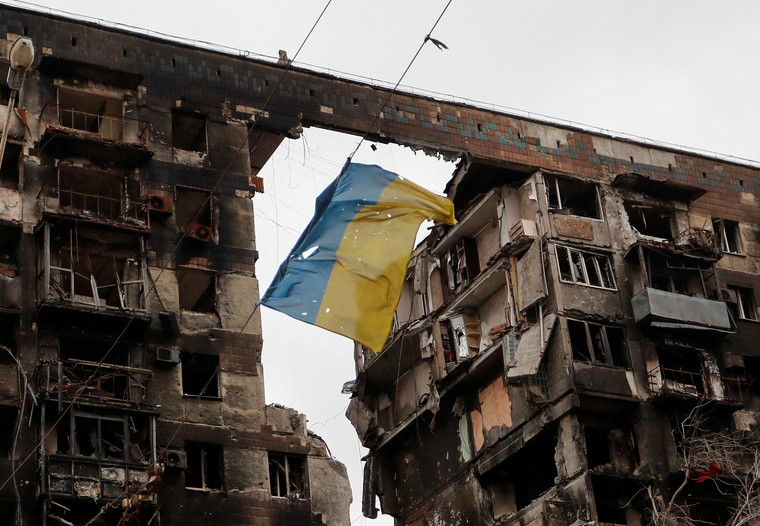 A view shows a Ukrainian flag near a destroyed building in Mariupol