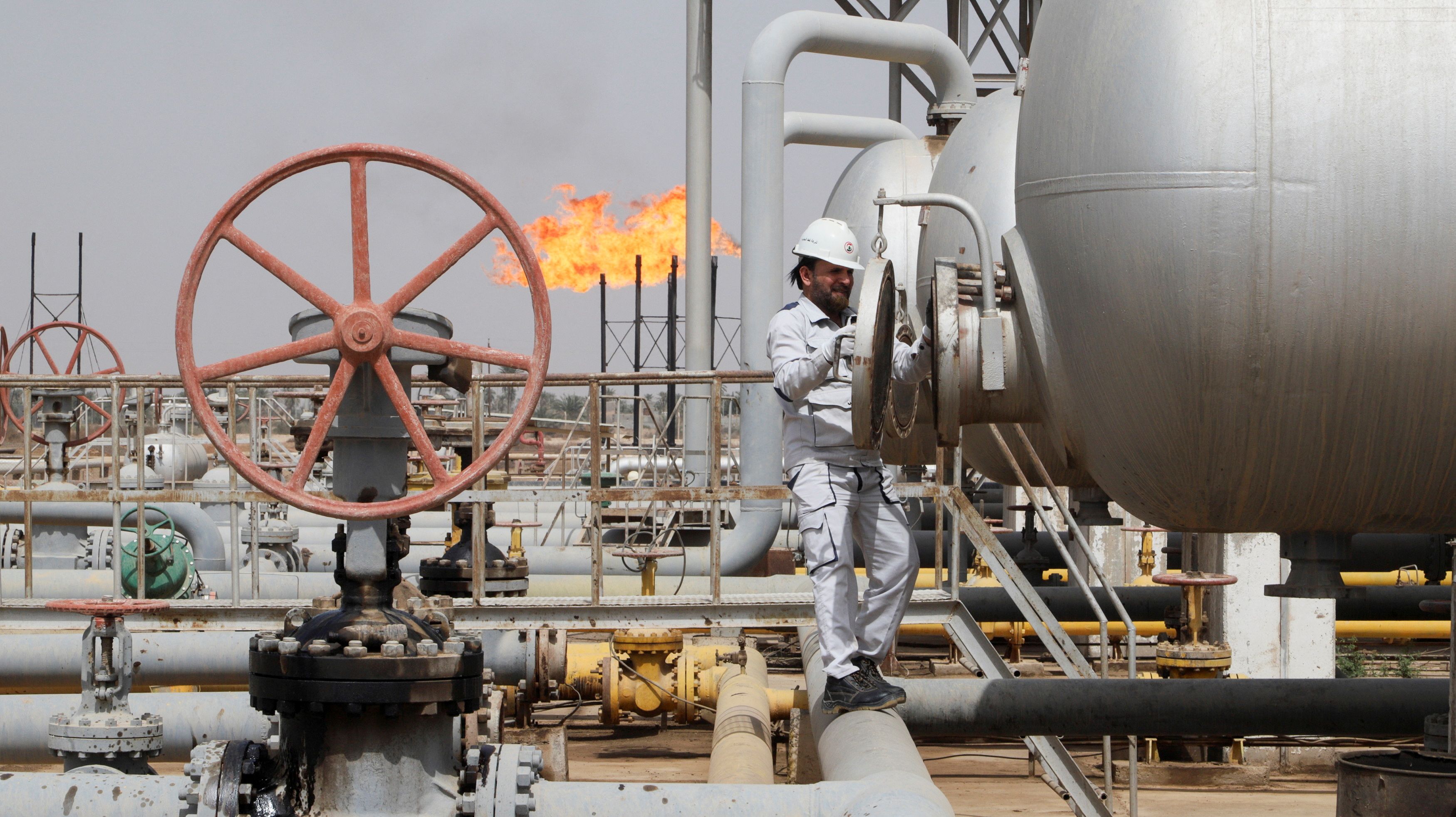 A worker checks a tank at Nahr Bin Umar oil field, north of Basra