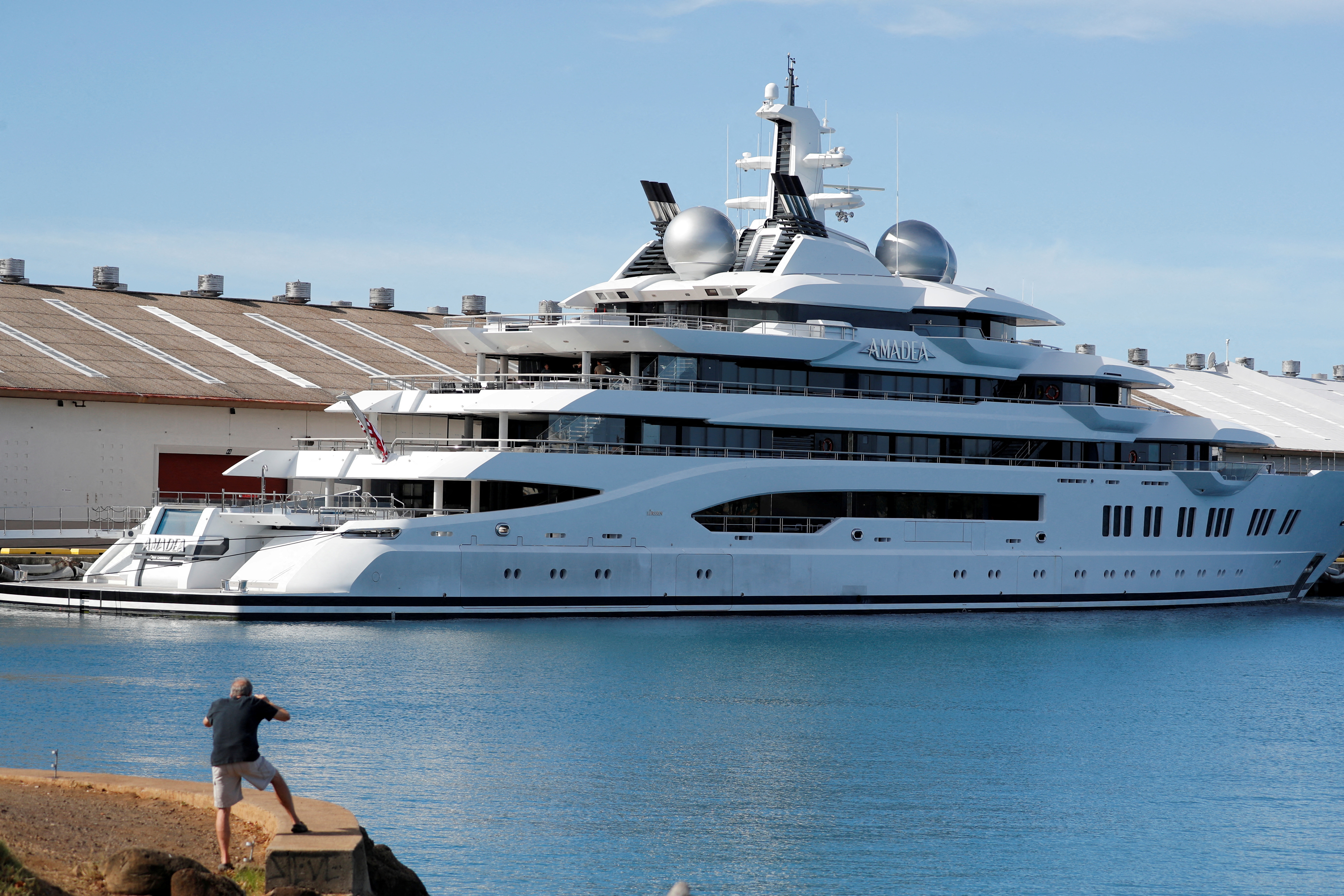 A man photographs the Russian-owned super yacht Amadea seized in Fiji by American law enforcement, in Honolulu