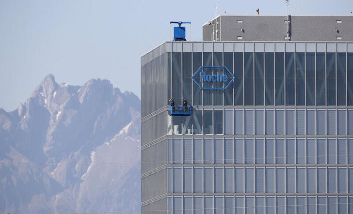 Workers clean windows of a building of Roche in Rotkreuz