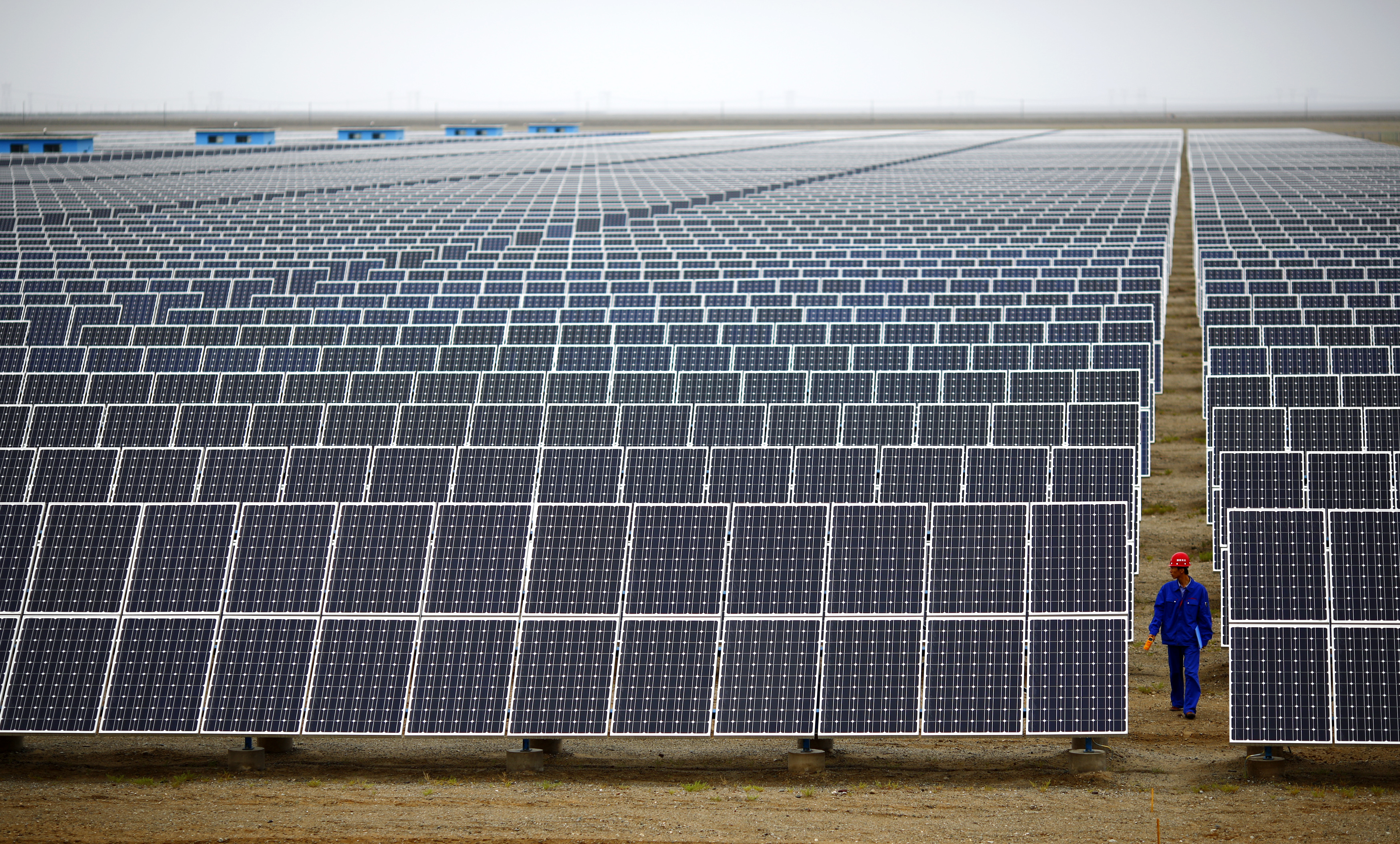A worker inspects solar panels at a solar farm in Dunhuang, 950km northwest of Lanzhou, Gansu Province