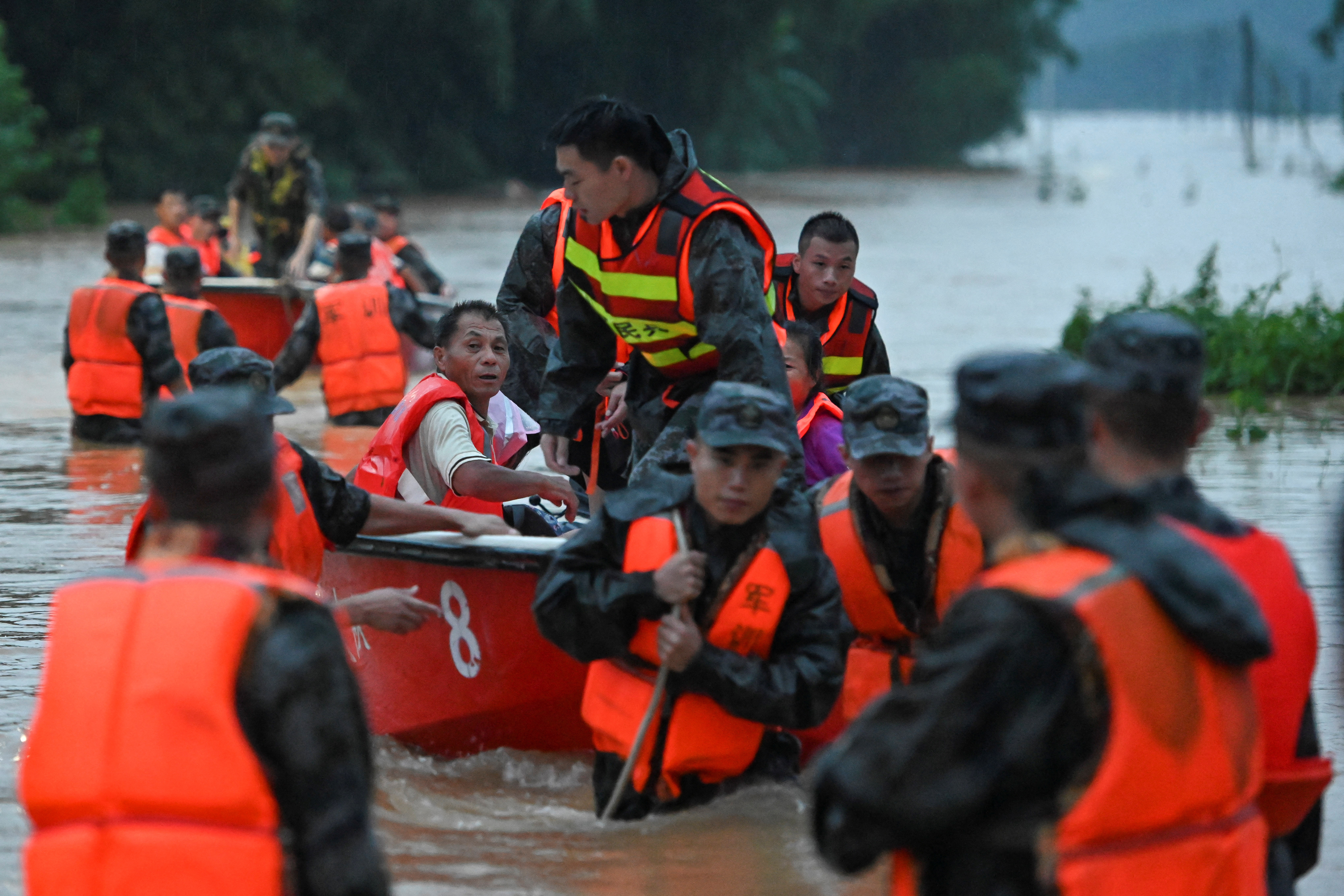 Rescue workers evacuate flood-affected residents from Xinli village with dinghies following heavy rainfall