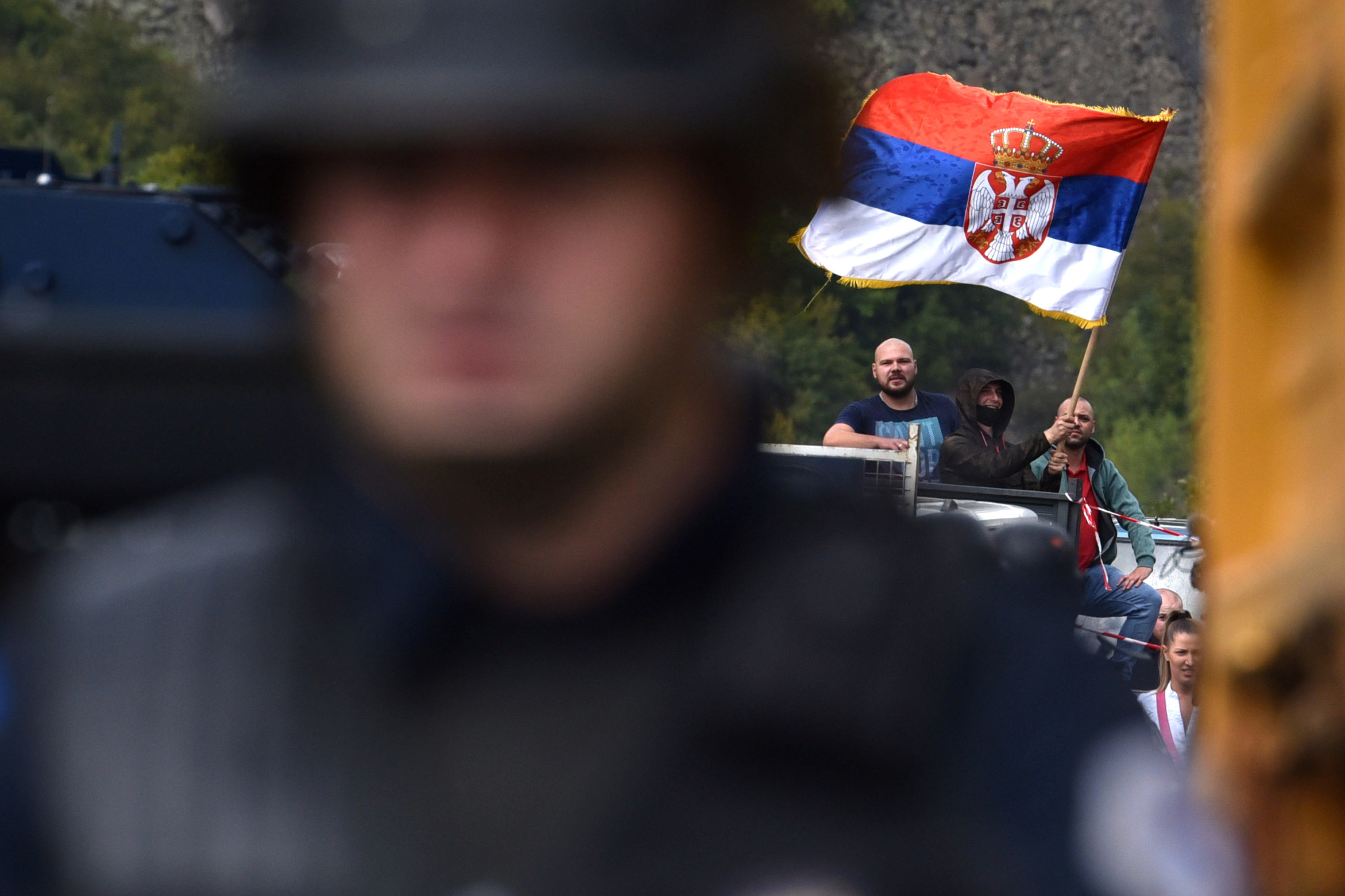 A Kosovo Serb is pictured waving a Serbian flag as he protests against a government ban on entry of vehicles with Serbian registration plates in Jarinje
