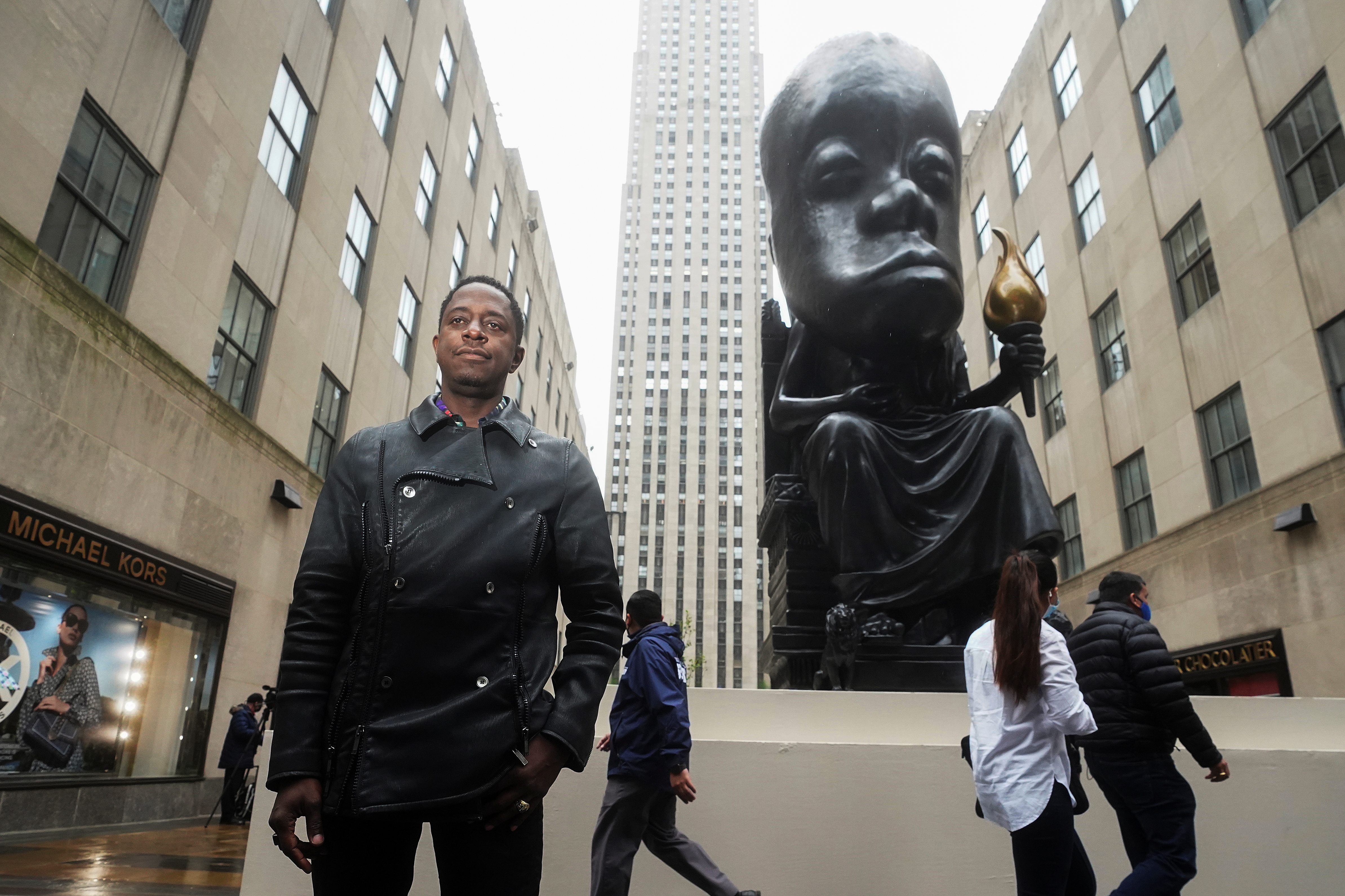 Sanford Biggers poses for a photo in front of his statue 'Oracle' in New York City