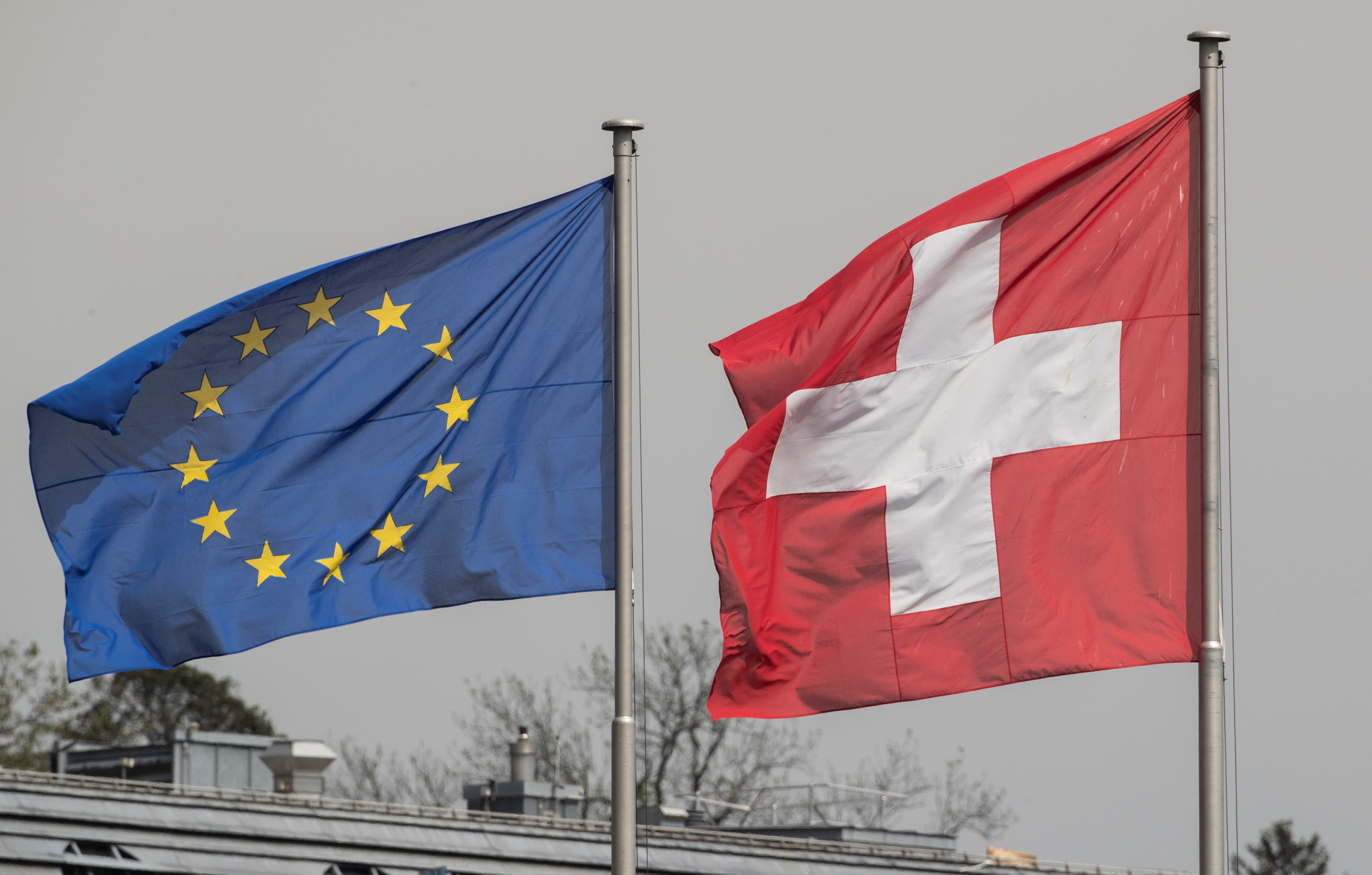 Switzerland's national flag flies beside the one of the European Union in Zurich