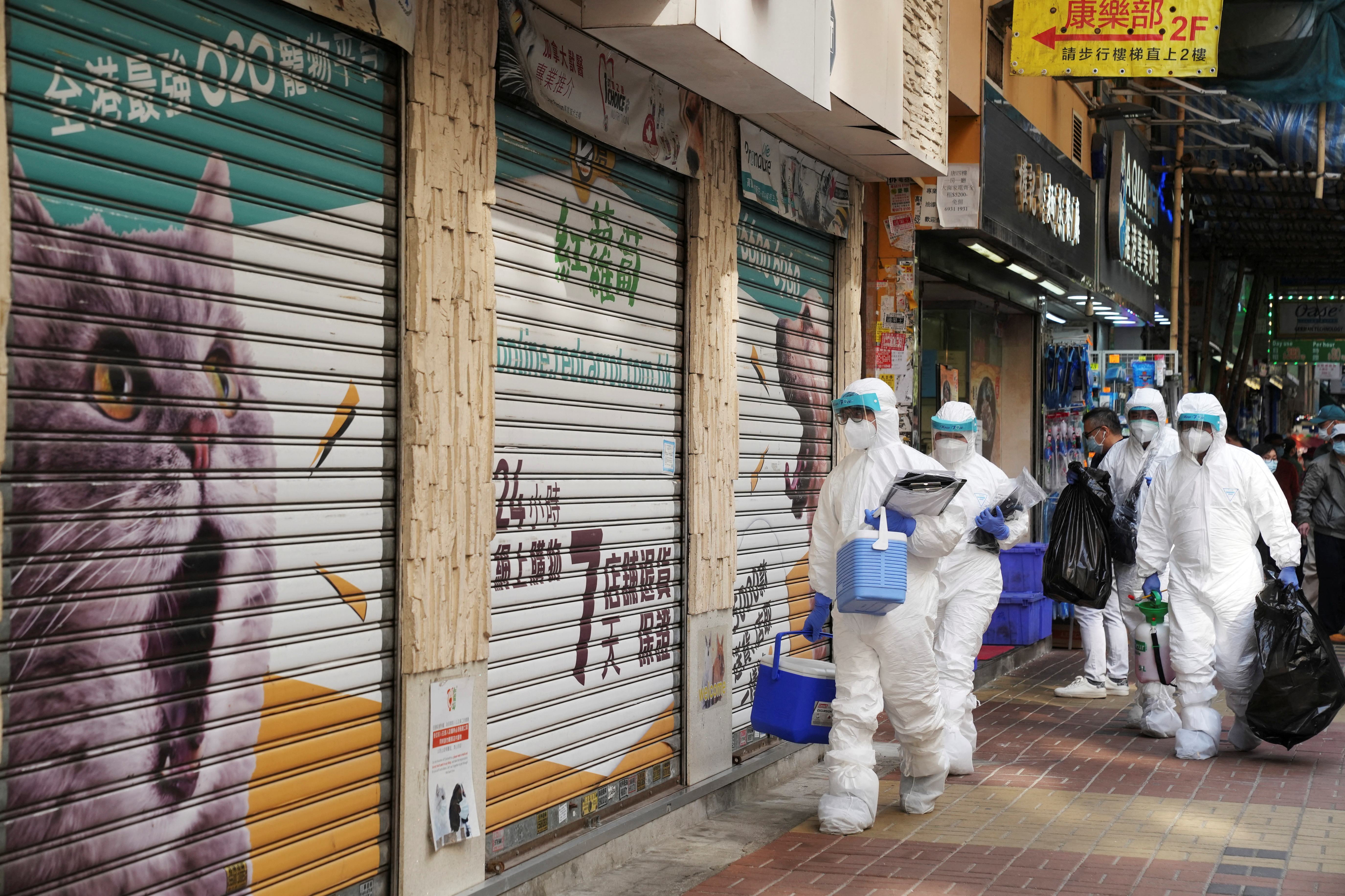 Officers in protective suits at a closed pet shop in Hong Kong