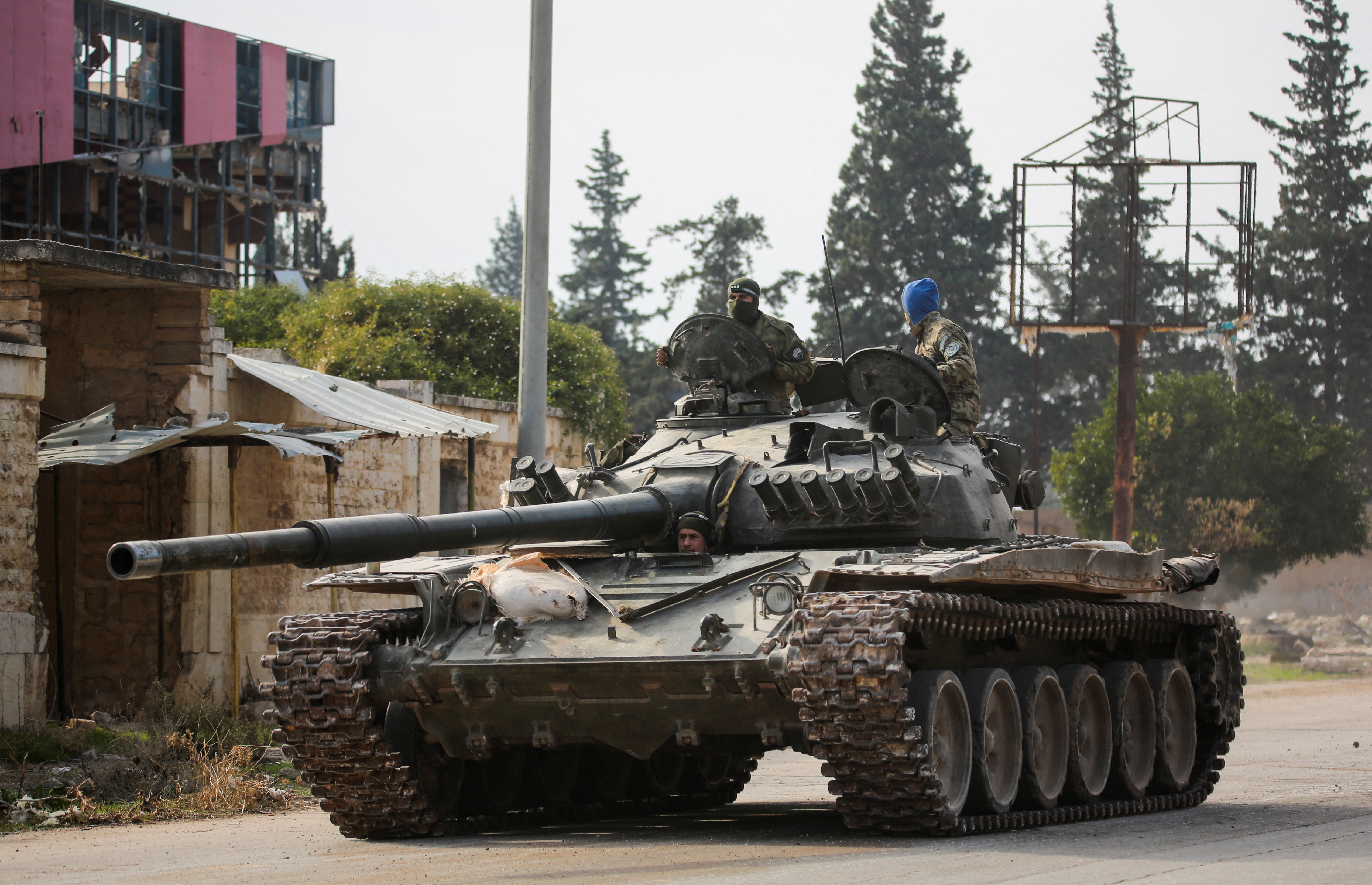 Rebels led by the Islamist militant group Hayat Tahrir al-Sham drive a military vehicle in al-Rashideen