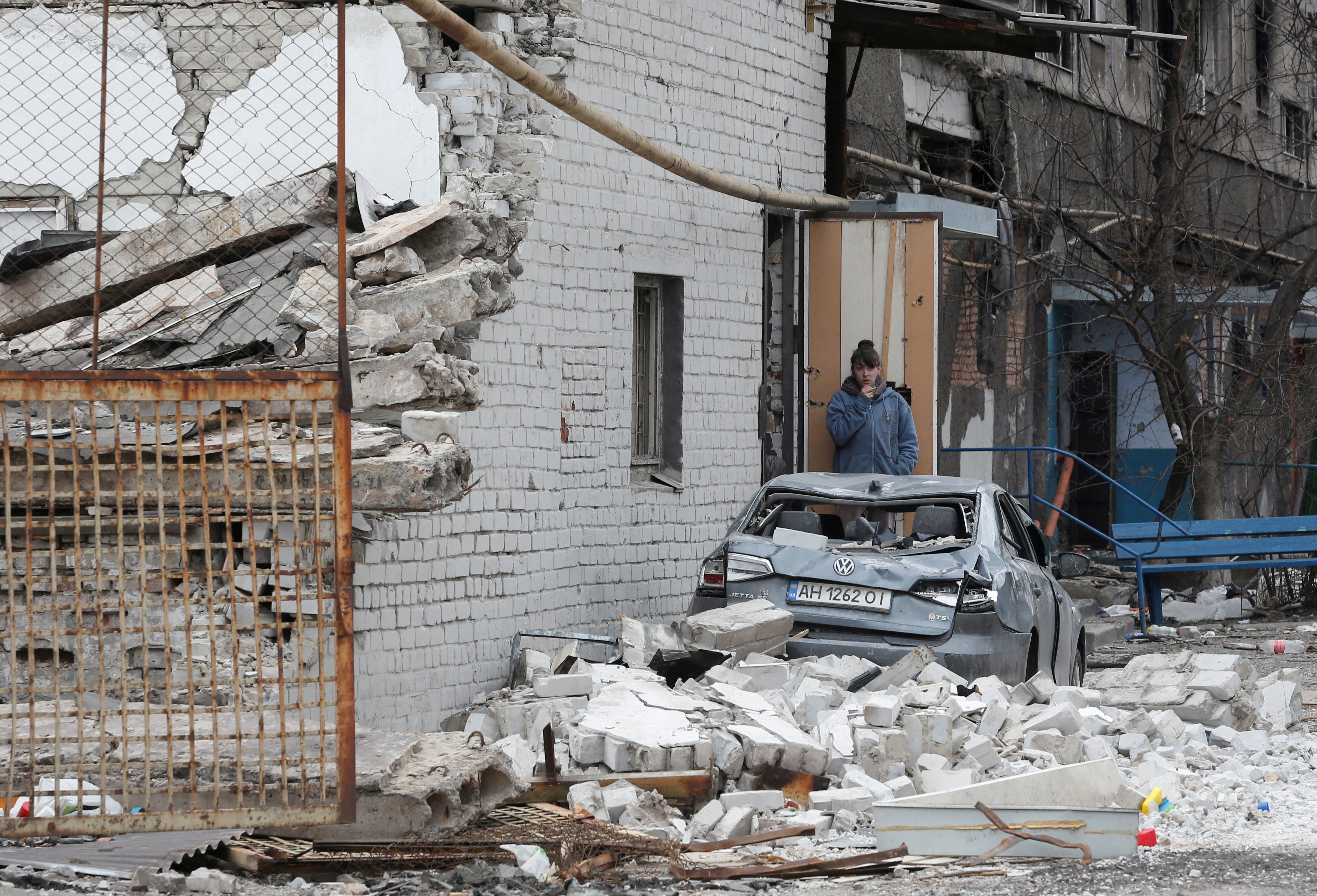A local resident stands near a damaged apartment building in Mariupol