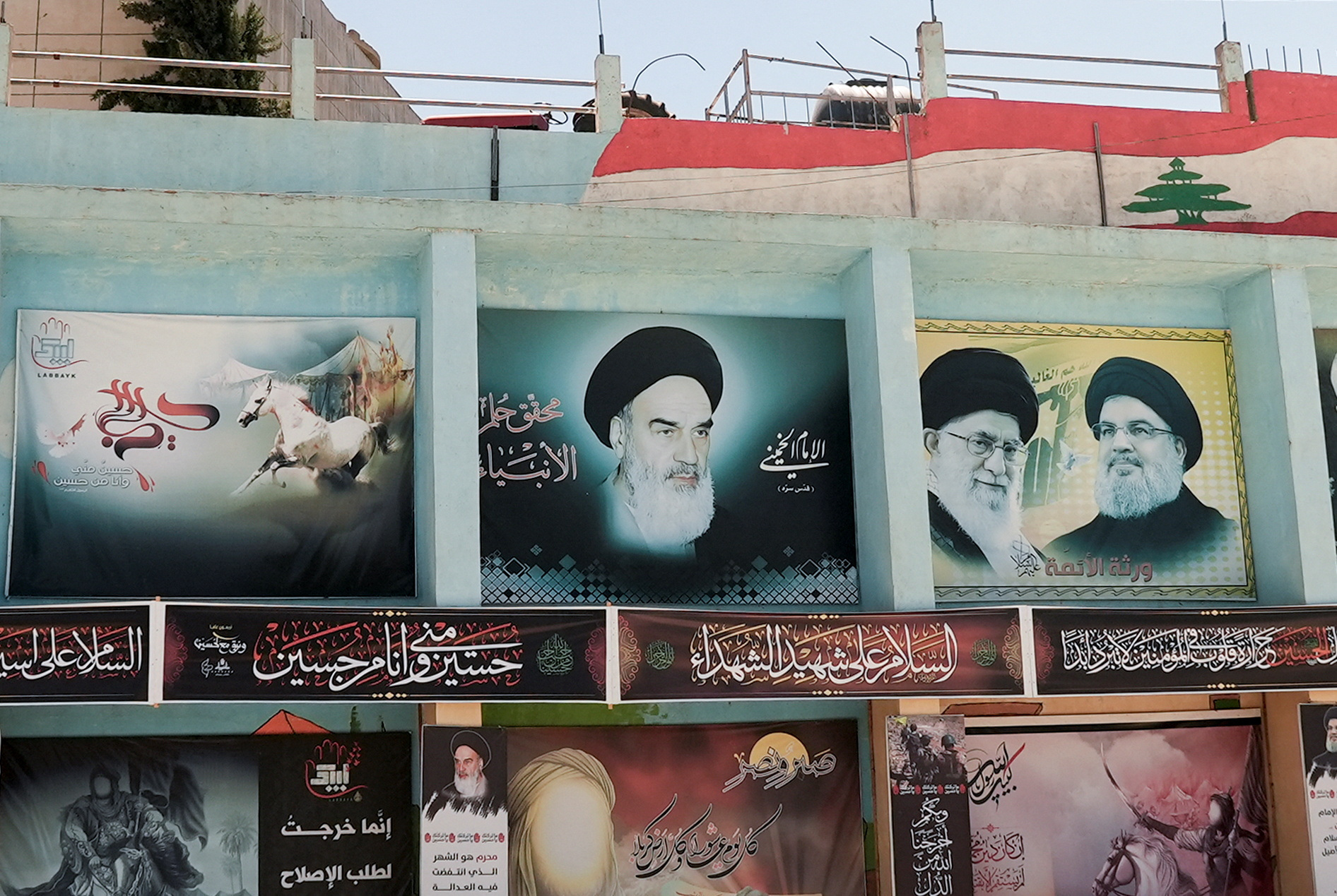 View of banners depicting Iran's Khomeini and Khamenei, and Lebanon's Nasrallah in Yaroun