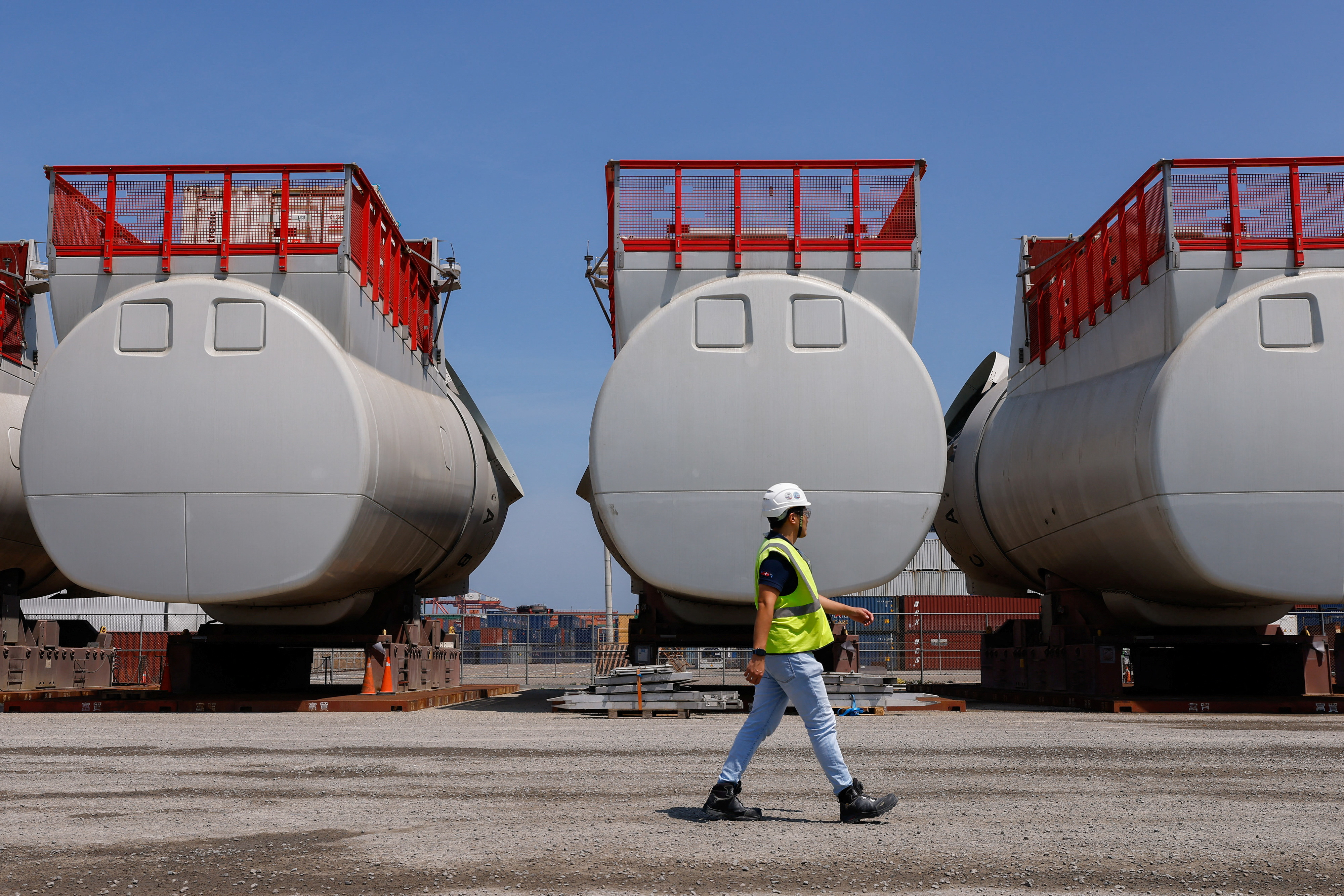 An Orsted employee walks in front of turbine parts at Orsted's pre-assembly site in Taichung Port, in Taichung