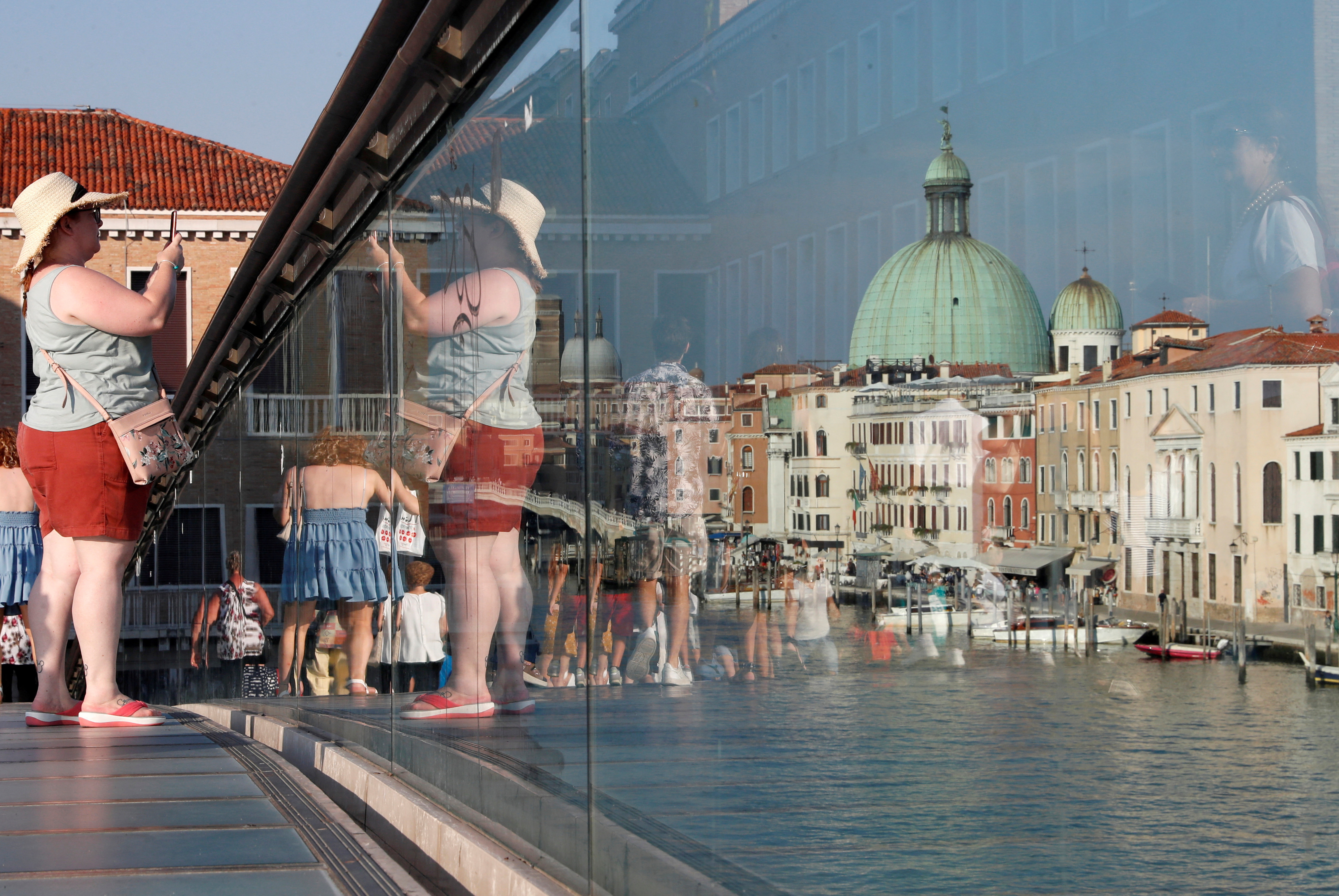 Woman takes a picture from Ponte della Costituzione (Constitution Bridge) in Venice