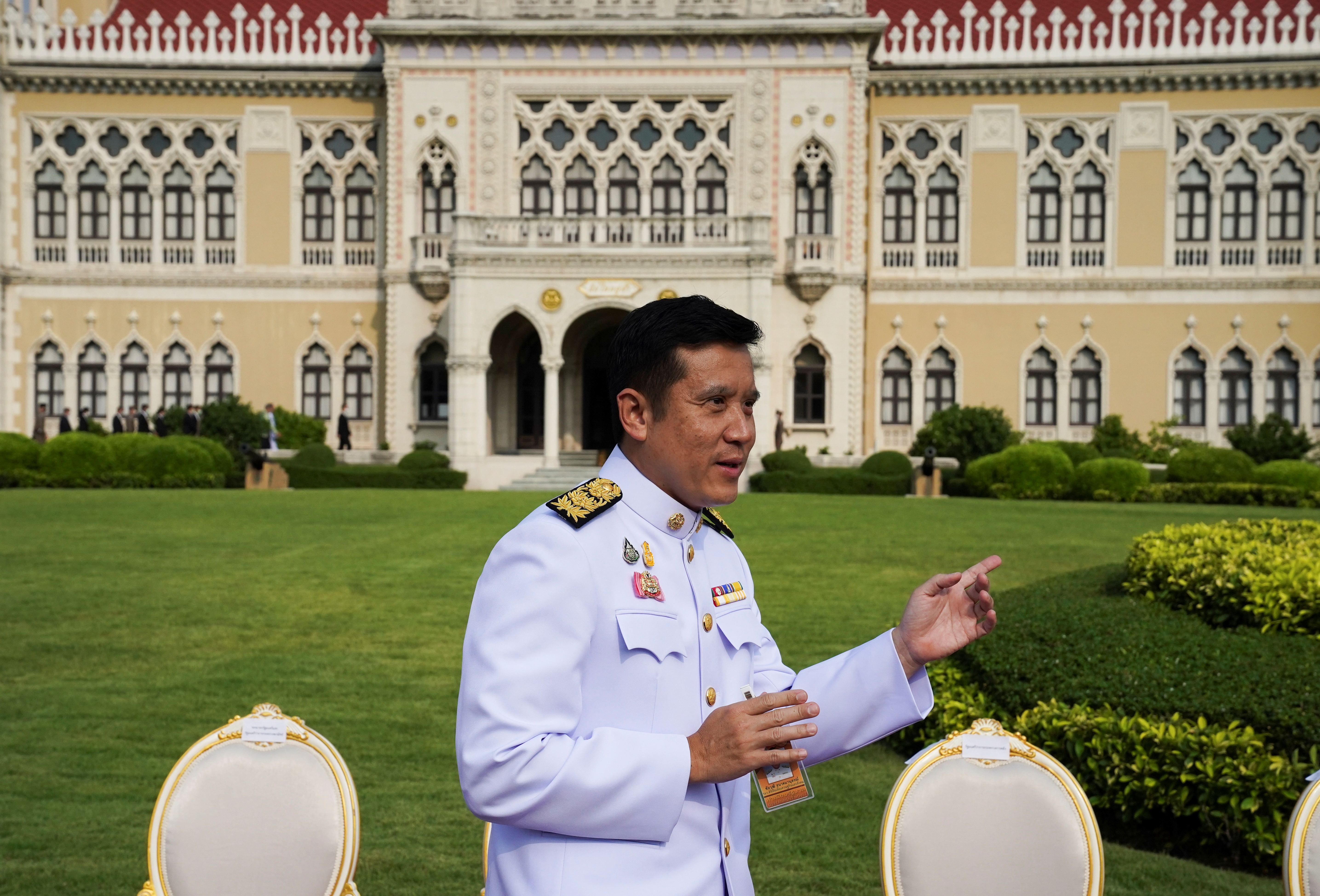 Thailand's Minister of Digital Economy and Society gestures after a family photo session at the Government House in Bangkok