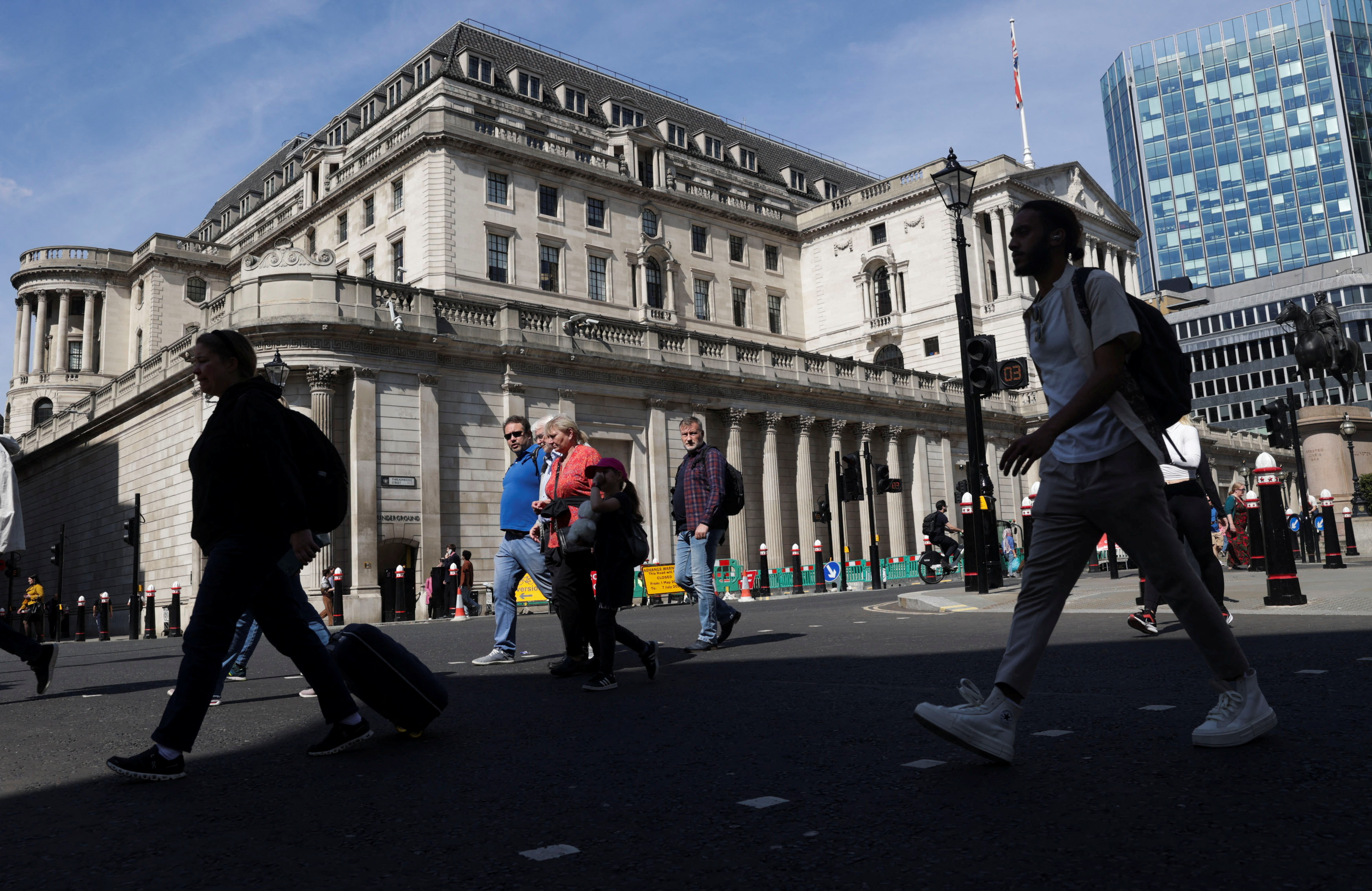 People walk past the Bank of England building, in London