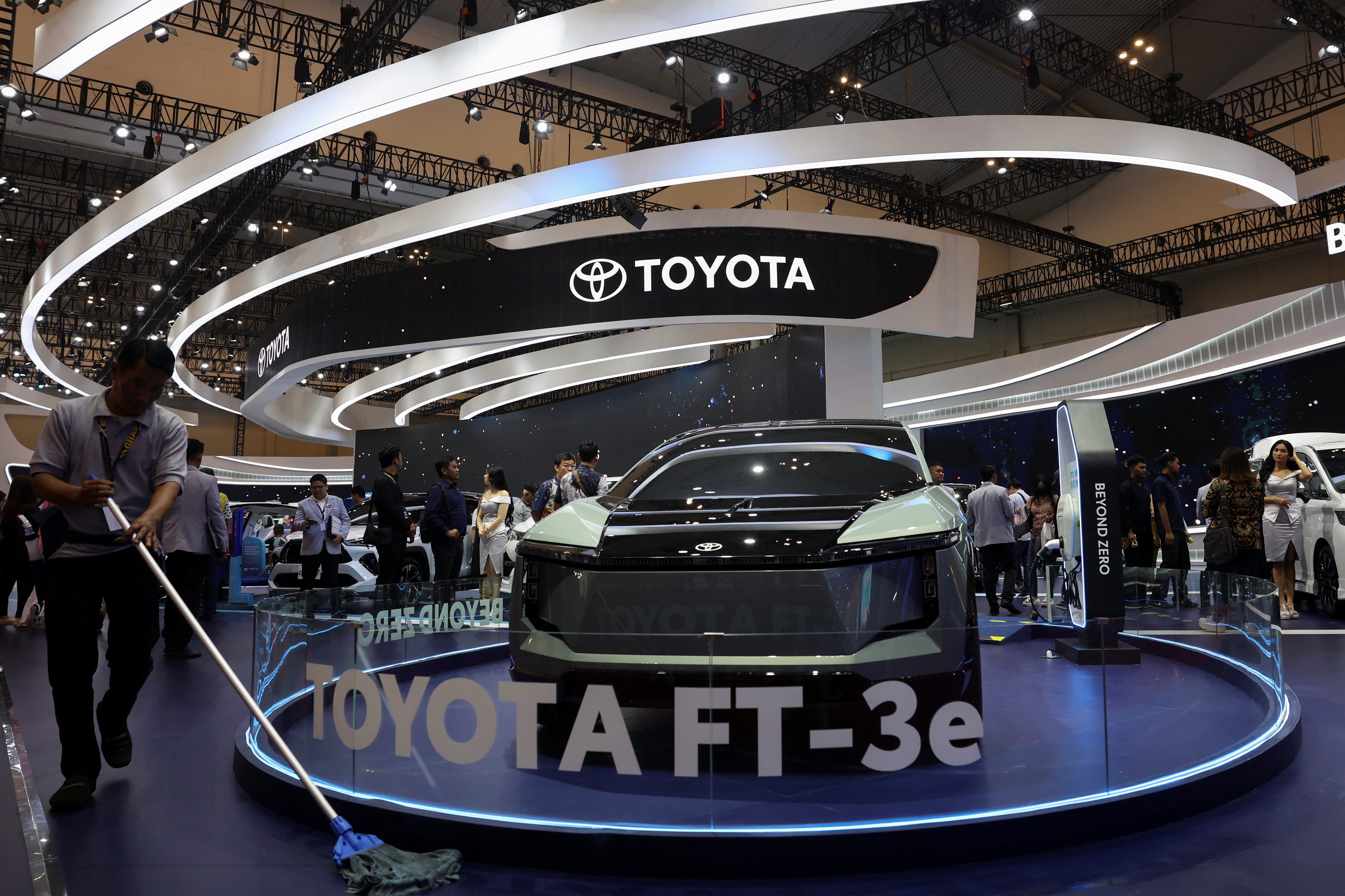 A man mops a floor near a Toyota FT-3e during the Indonesia International Auto Show in Tangerang