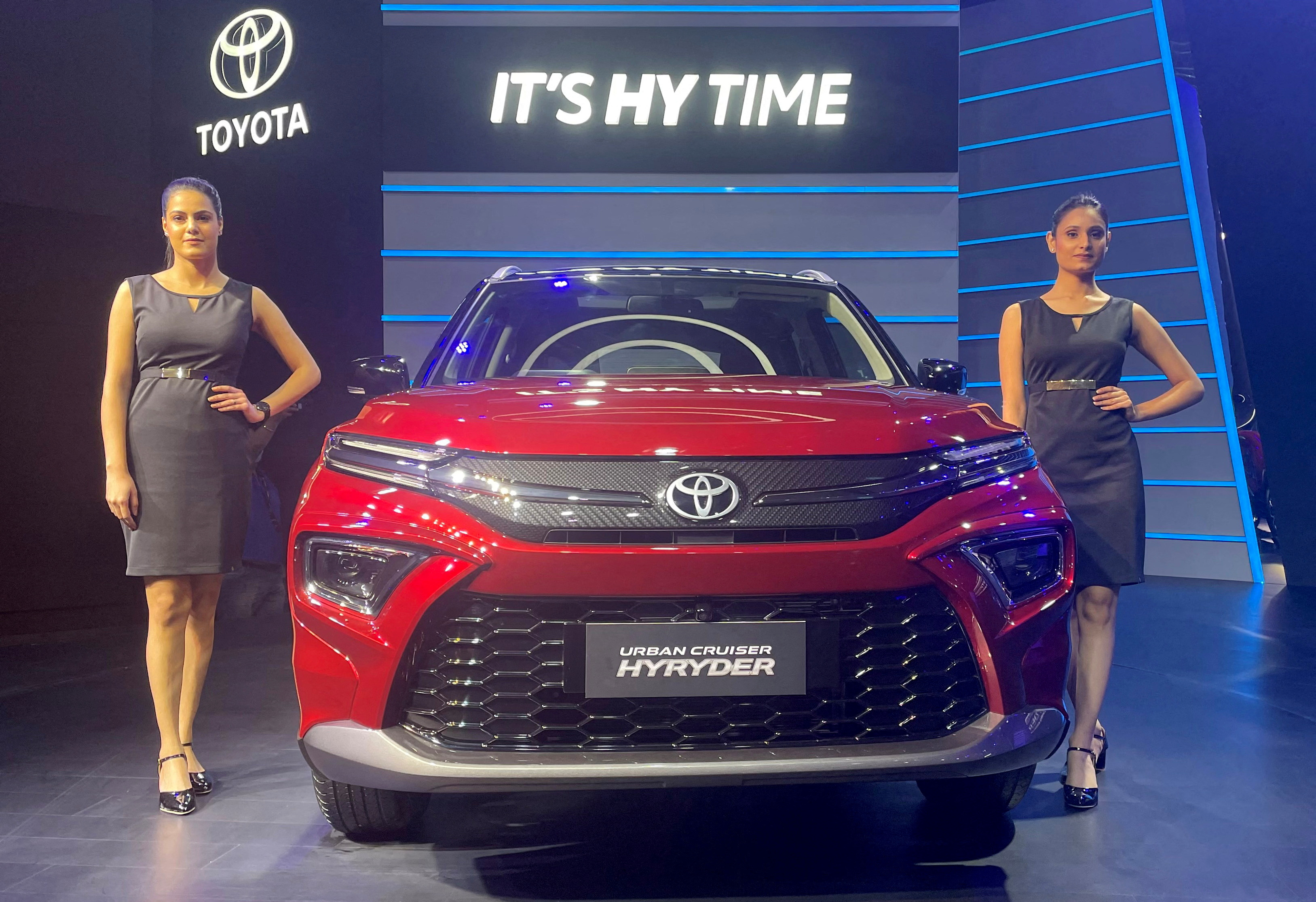 Models pose at the unveiling of Toyota's new hybrid SUV Urban Cruiser Hyryder in New Delhi