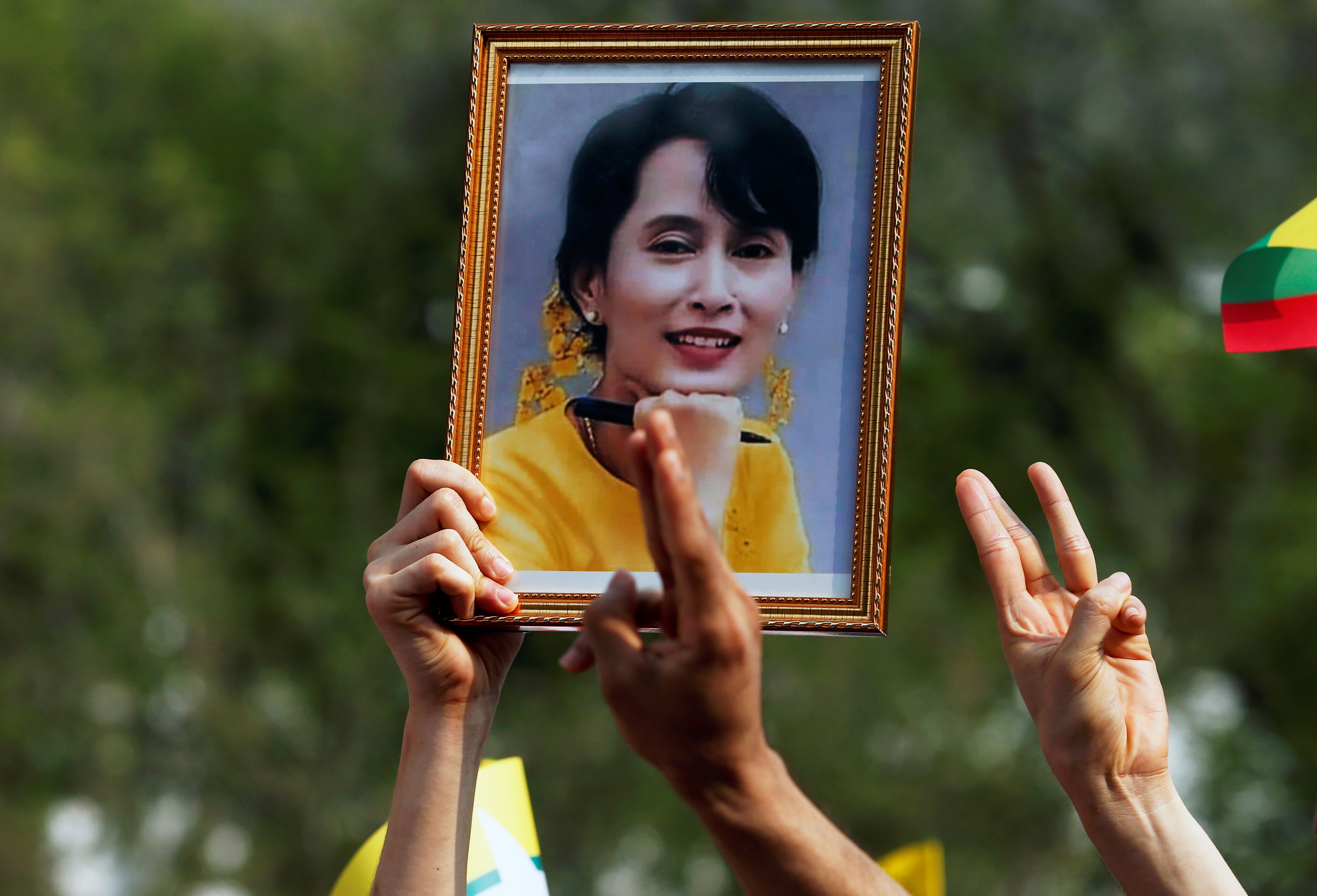 A person holds a picture of leader Aung San Suu Kyi as Myanmar citizens protest against the military coup in front of the U.N. office in Bangkok, Thailand February 22, 2021. REUTERS/Soe Zeya Tun/Files