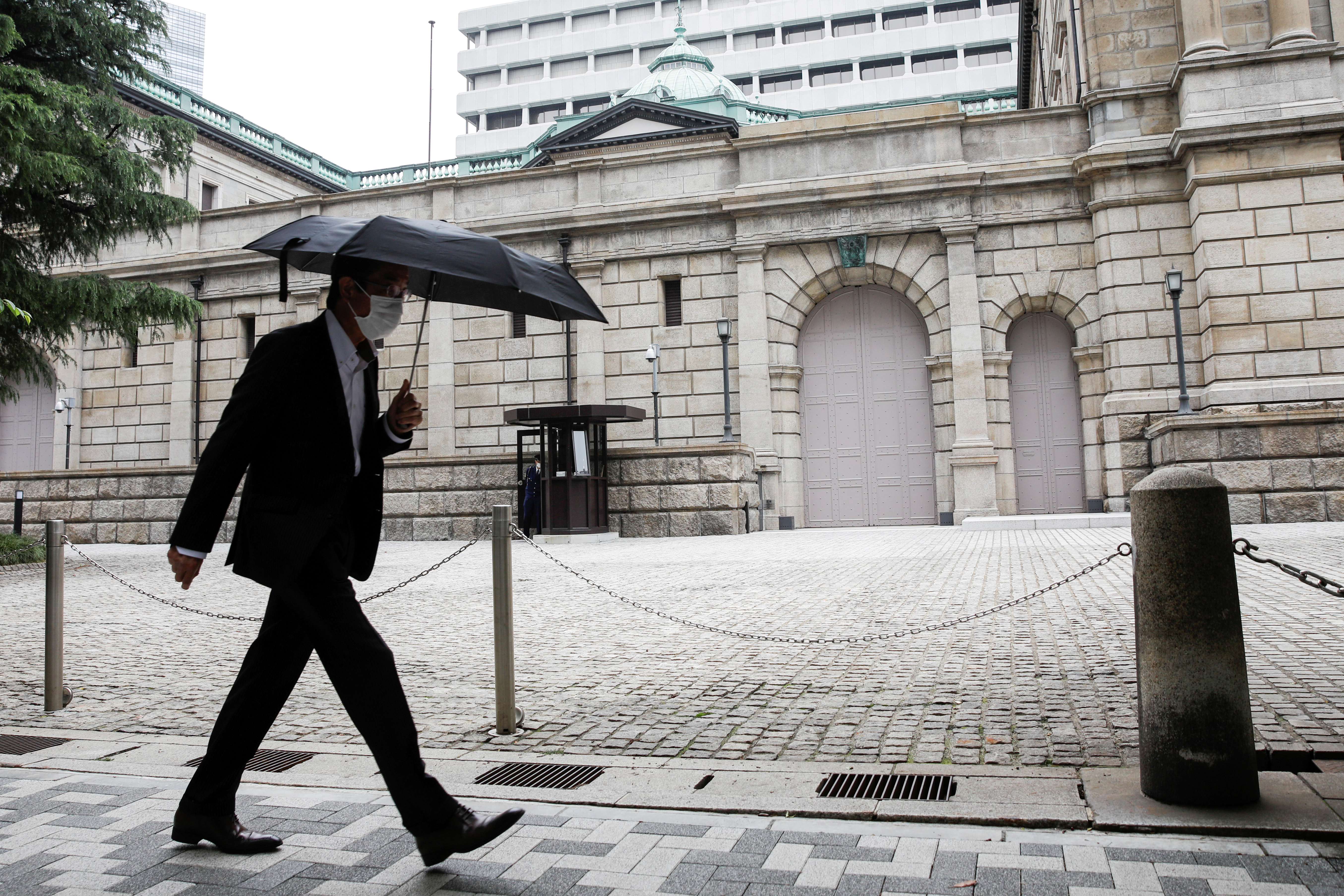 A man wearing a protective mask walks past the headquarters of Bank of Japan amid the coronavirus disease (COVID-19) outbreak in Tokyo
