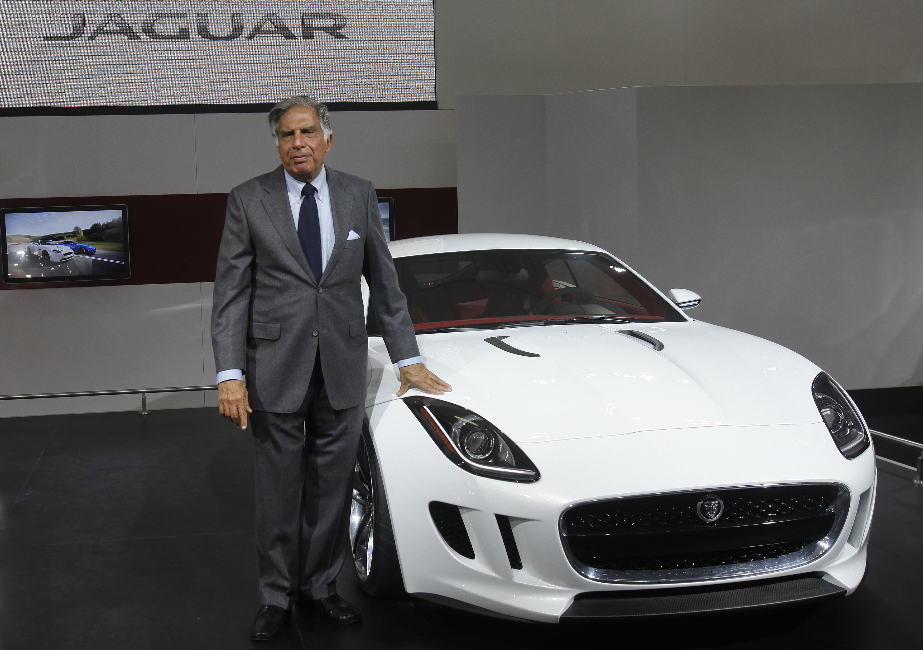 Chairman of Tata Group Tata poses with Jaguar's newly launched C-X16 car during India's Auto Expo, in New Delhi