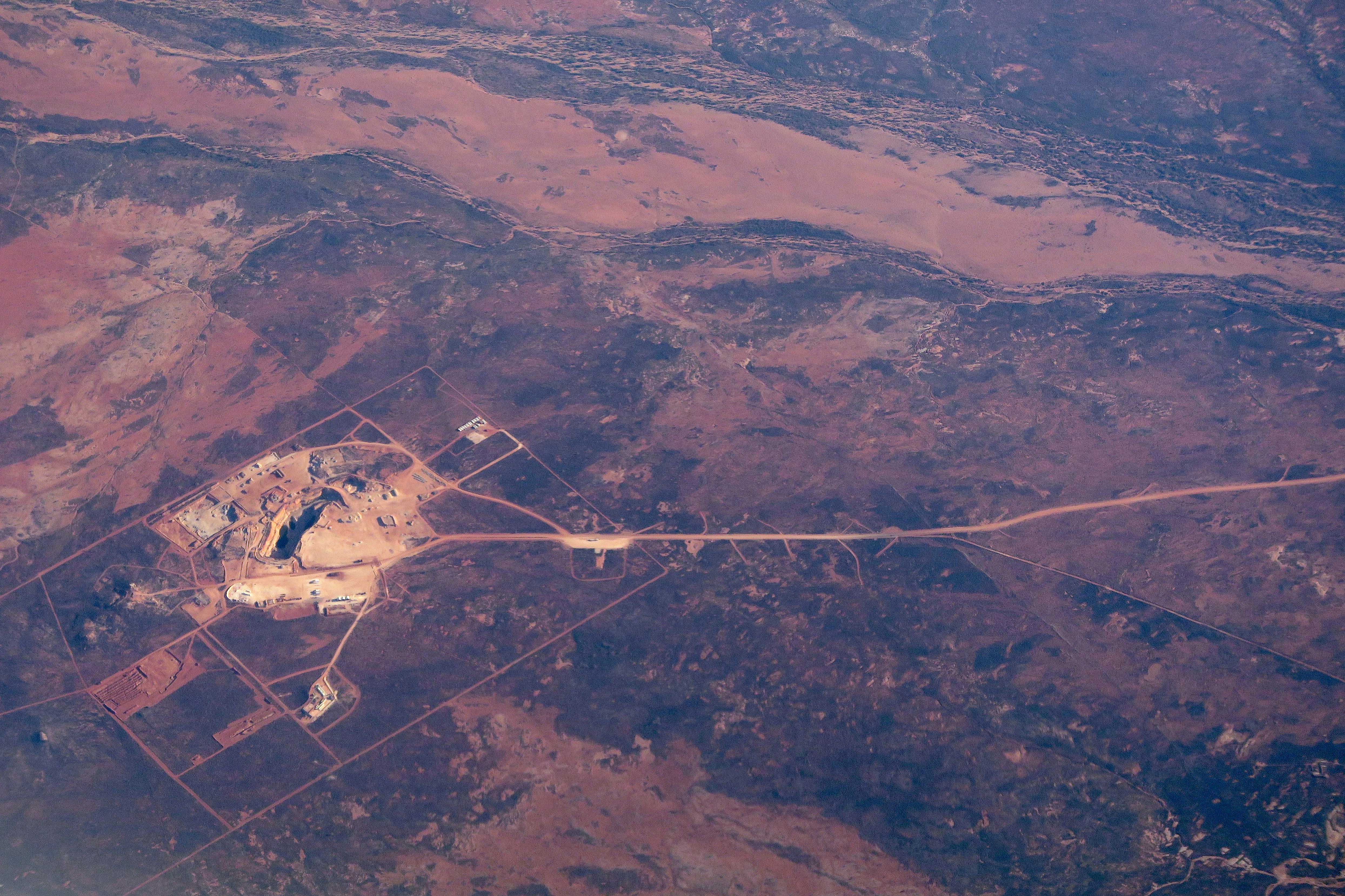 A road leads to an open-cut mine in the area known as the Pilbara region located in the north-west of Western Australia