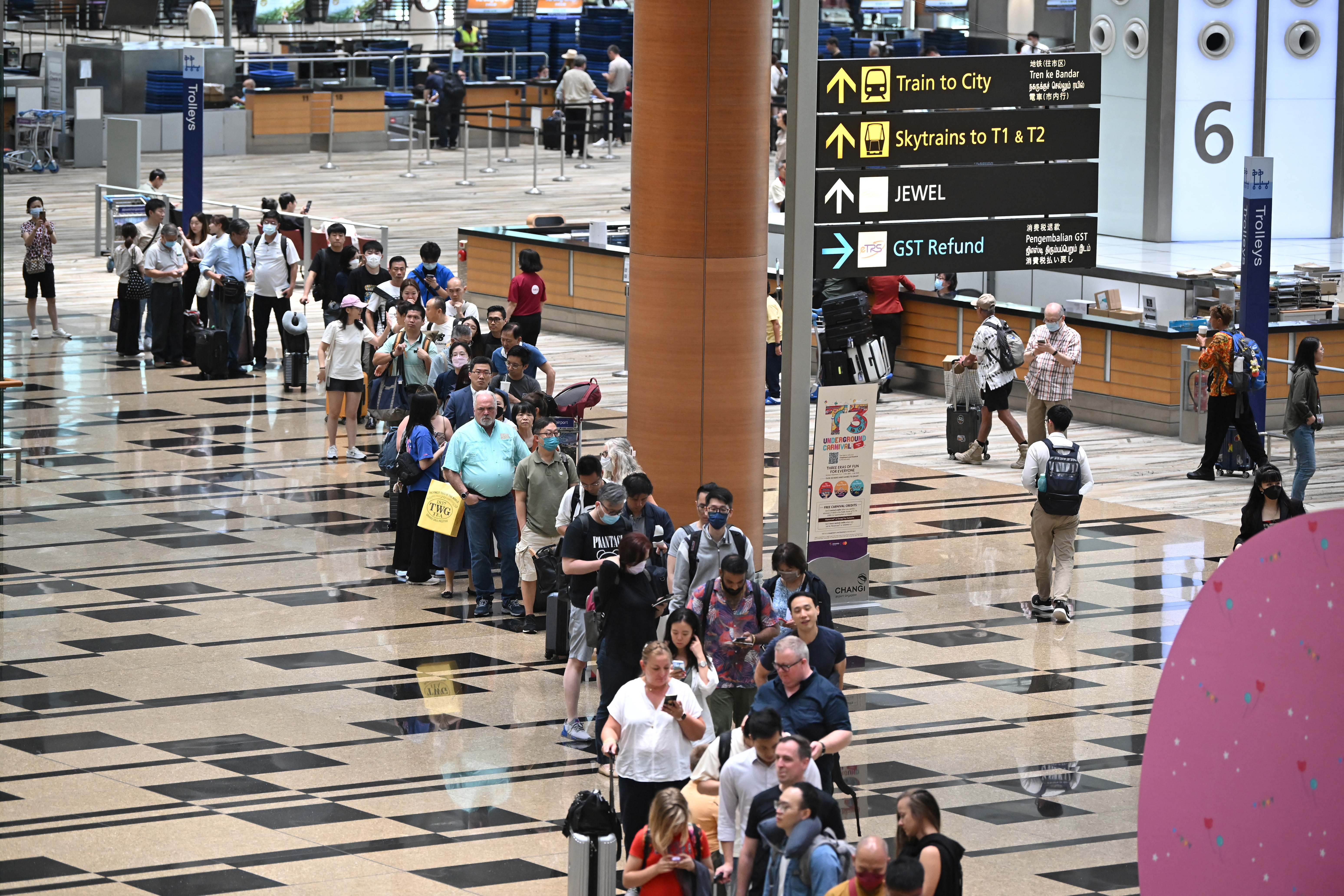 Passengers queue at the departure hall of Changi Airport Terminal 3 in Singapore