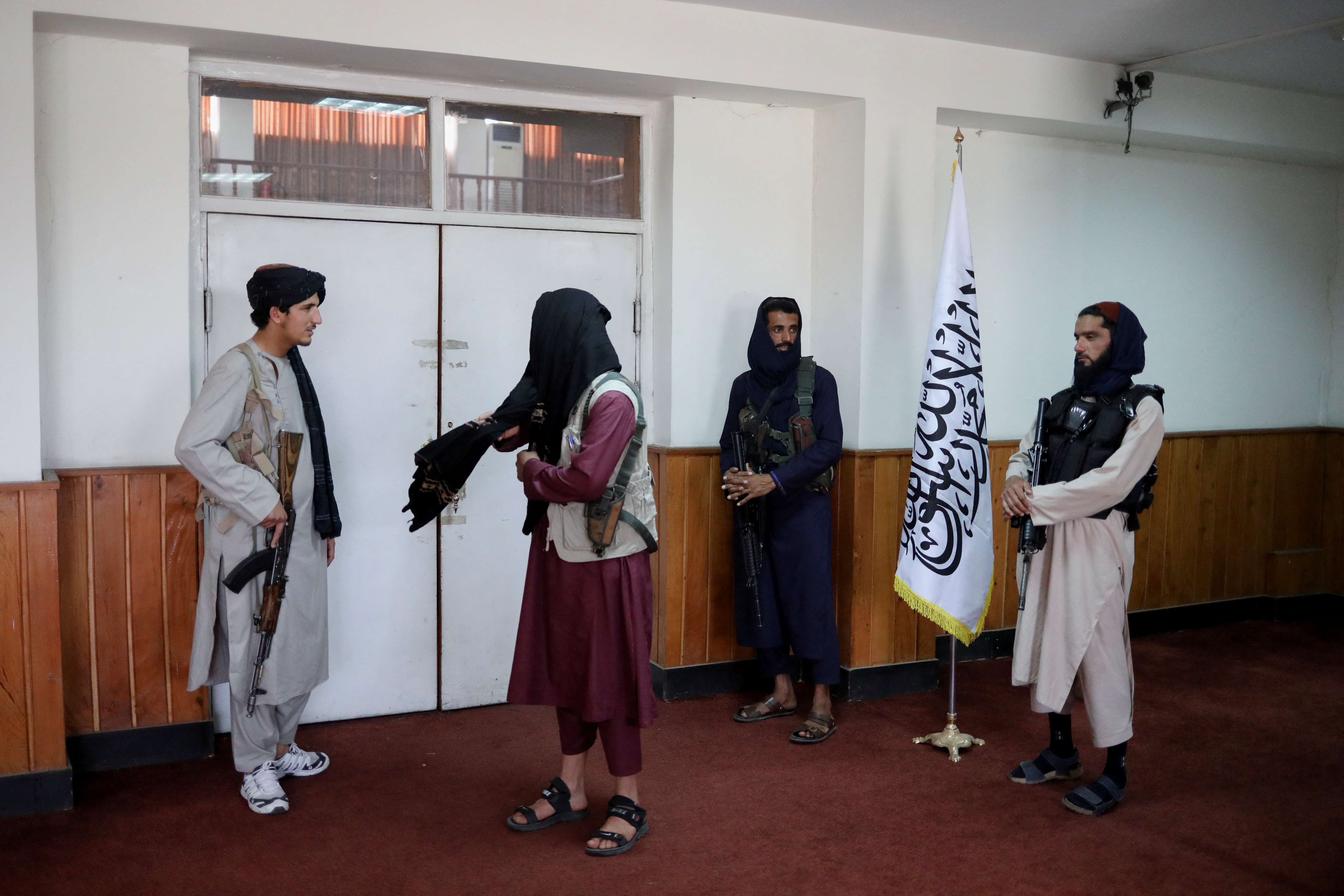 Taliban fighters stand guard at a news conference about a new command of hijab by Taliban leader Mullah Haibatullah Akhundzada, in Kabul