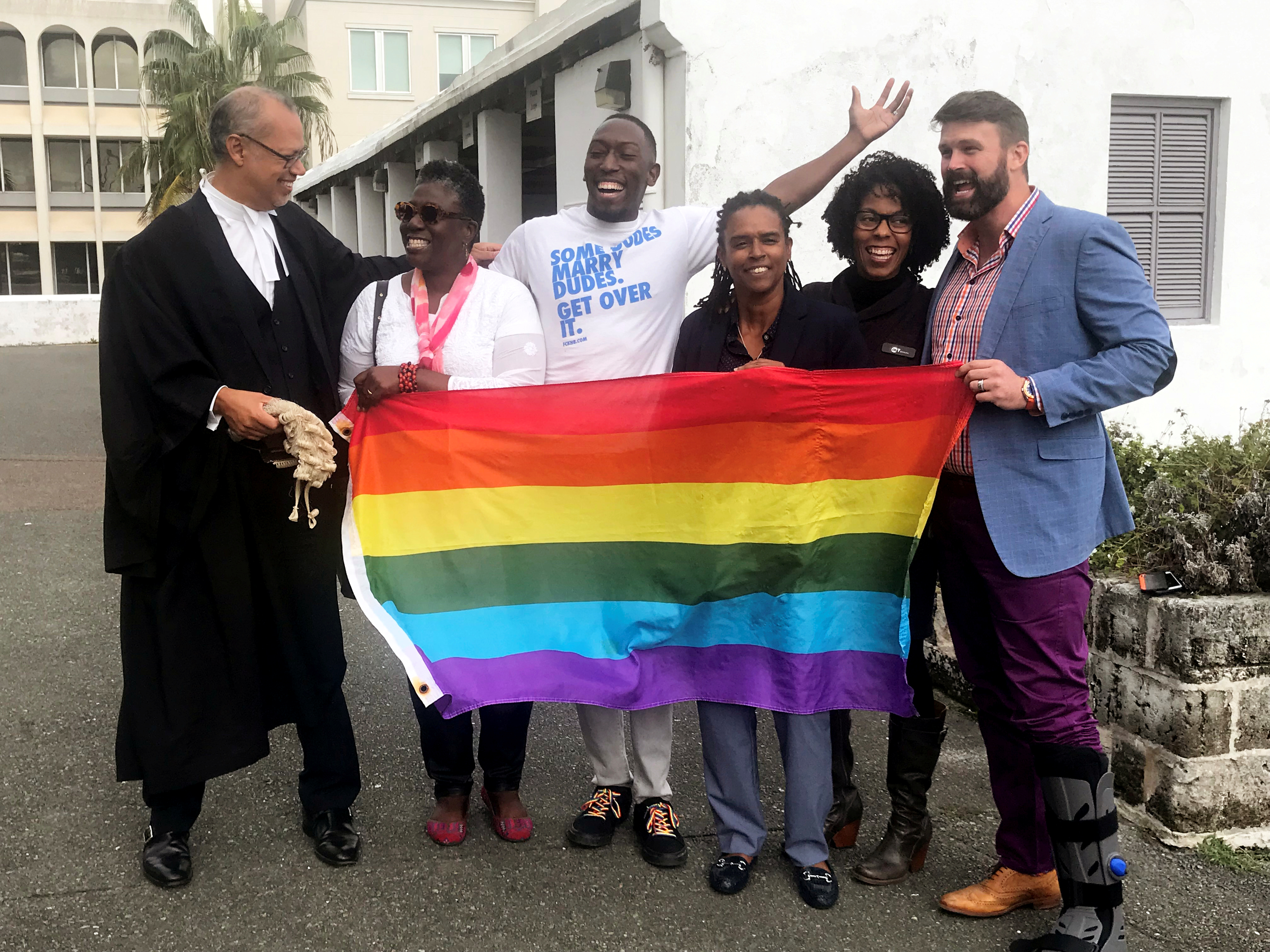 Rod Attride-Stirling, a lawyer who successfully challenged legislation banning gay marriage, poses for a photograph with gay rights supporters in front of court after the hearing, in Hamilton