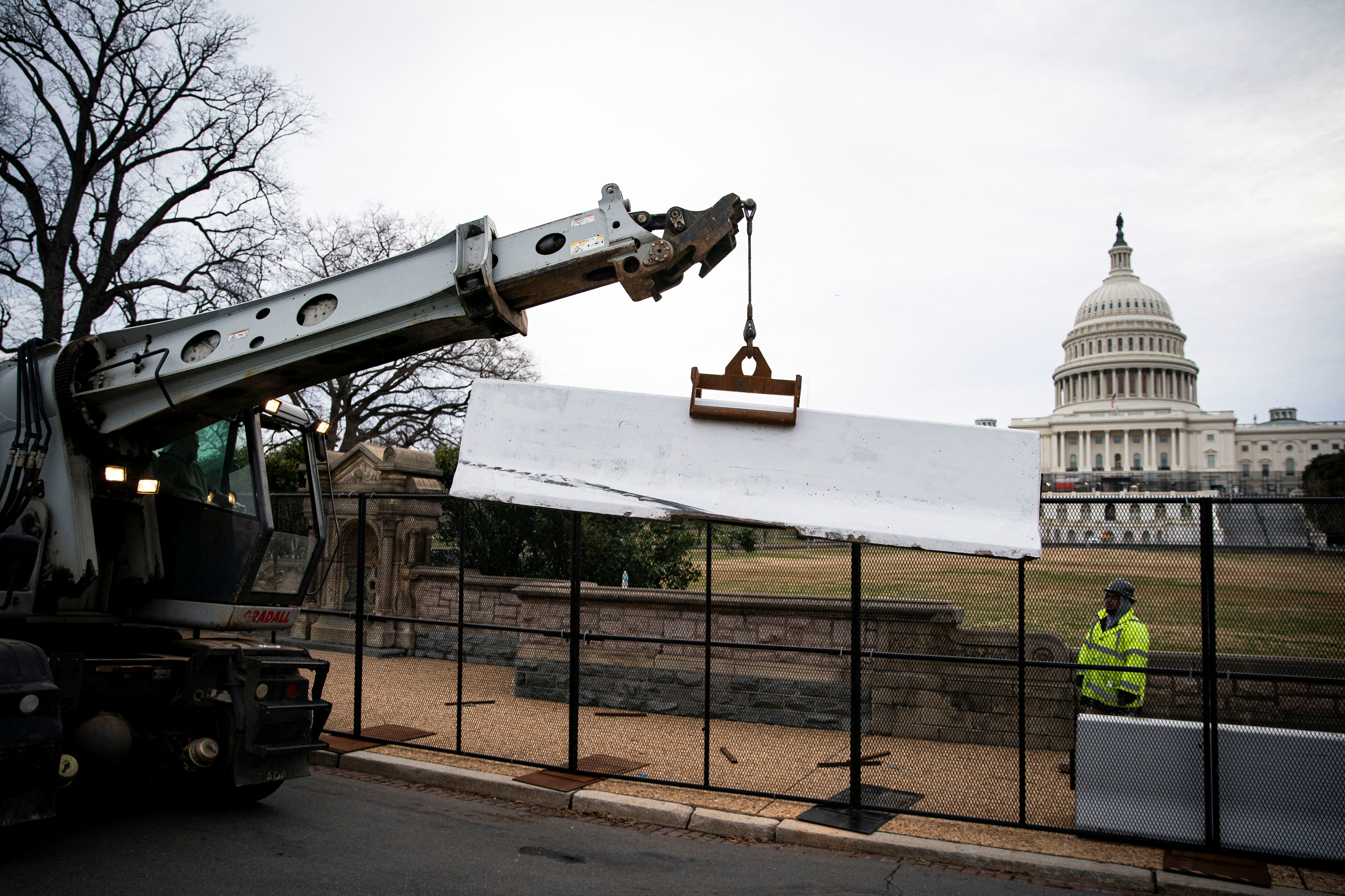 Workers install security fencing around the perimeter of the U.S. Capitol, ahead of the upcoming State of the Union with U.S. President Joe Biden