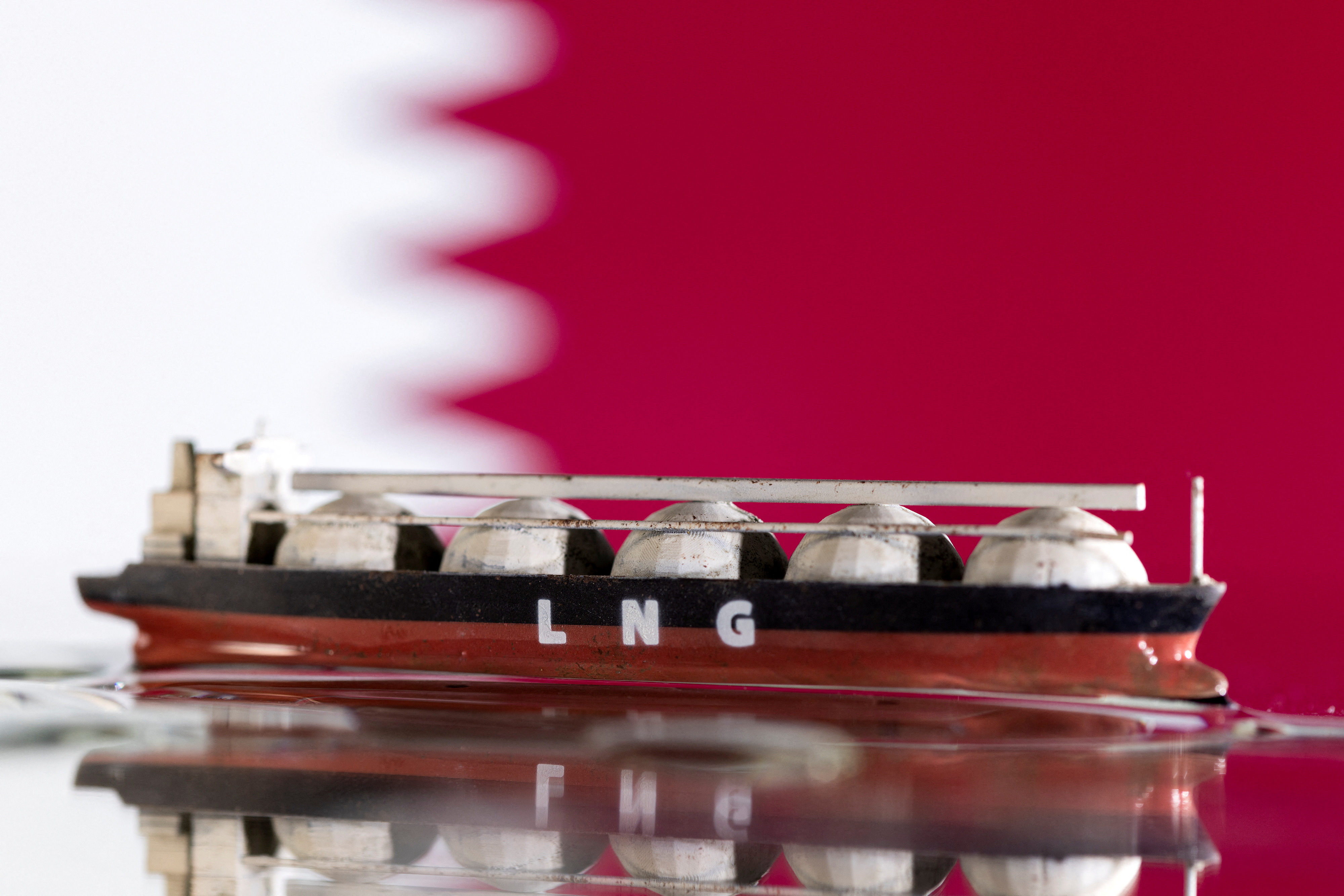 Illustration shows model of LNG tanker and Qatar's flag