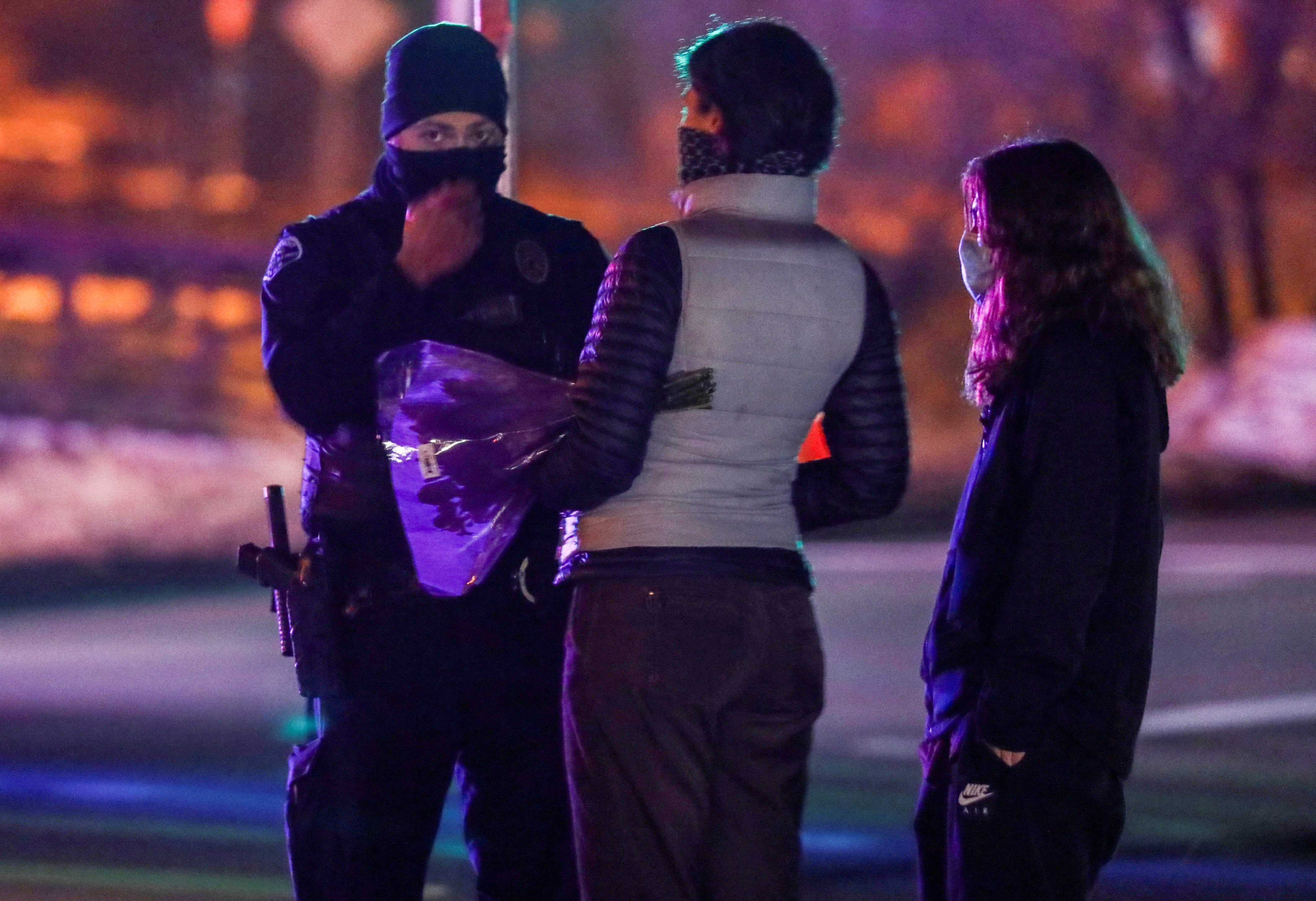 US: Mass shooting suspect identified, charged with 10 murder counts, motive unclear 6 Boulder residents Jessica Adams and her daughter Ruby Lopez talk to a member of law enforcement as they bring flowers to the site of a shooting in Boulder, Colorado, U.S. March 22, 2021. REUTERS/Jim Urquhart