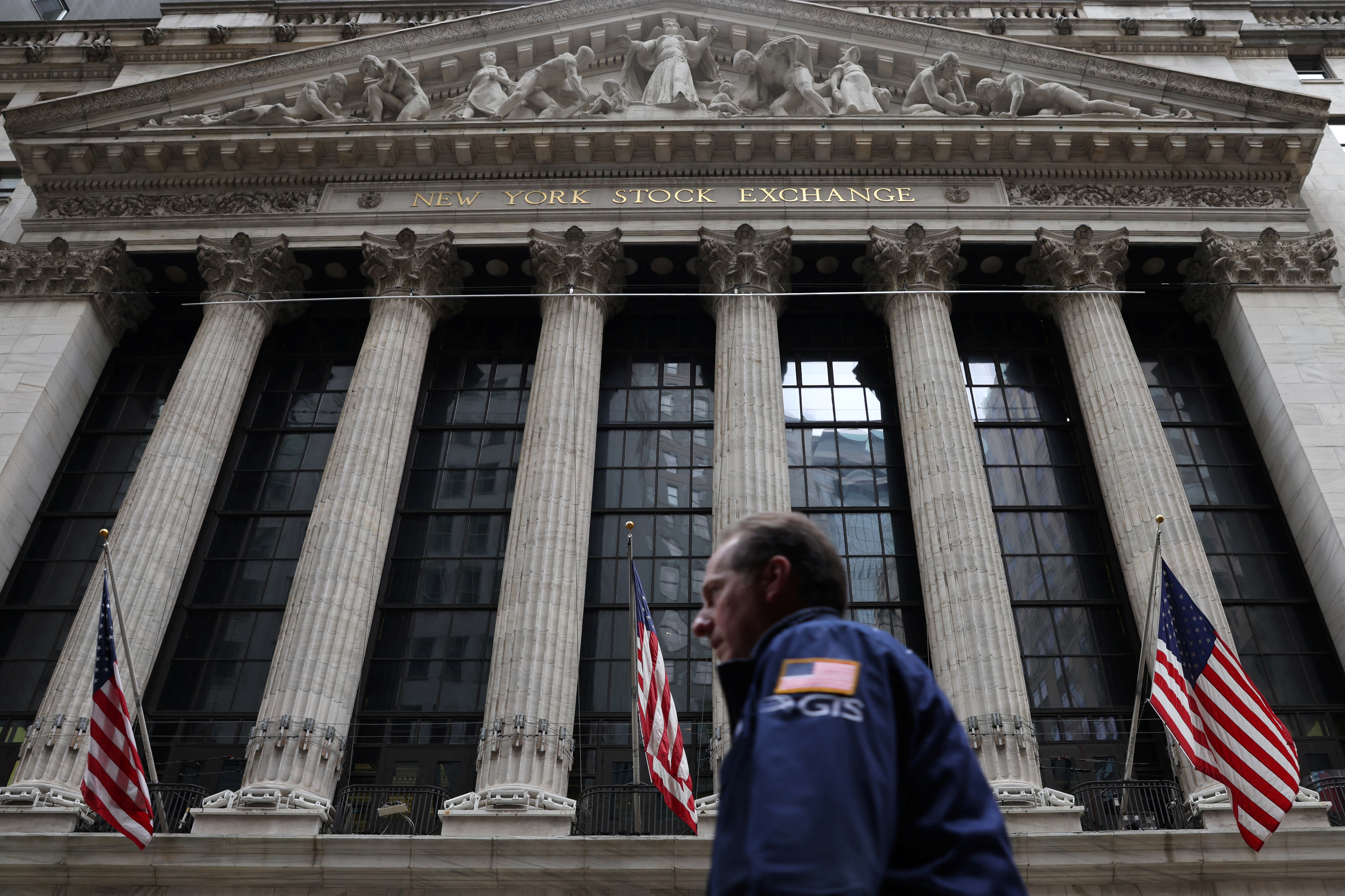 A trader walks by the New York Stock Exchange (NYSE) in Manhattan, New York City