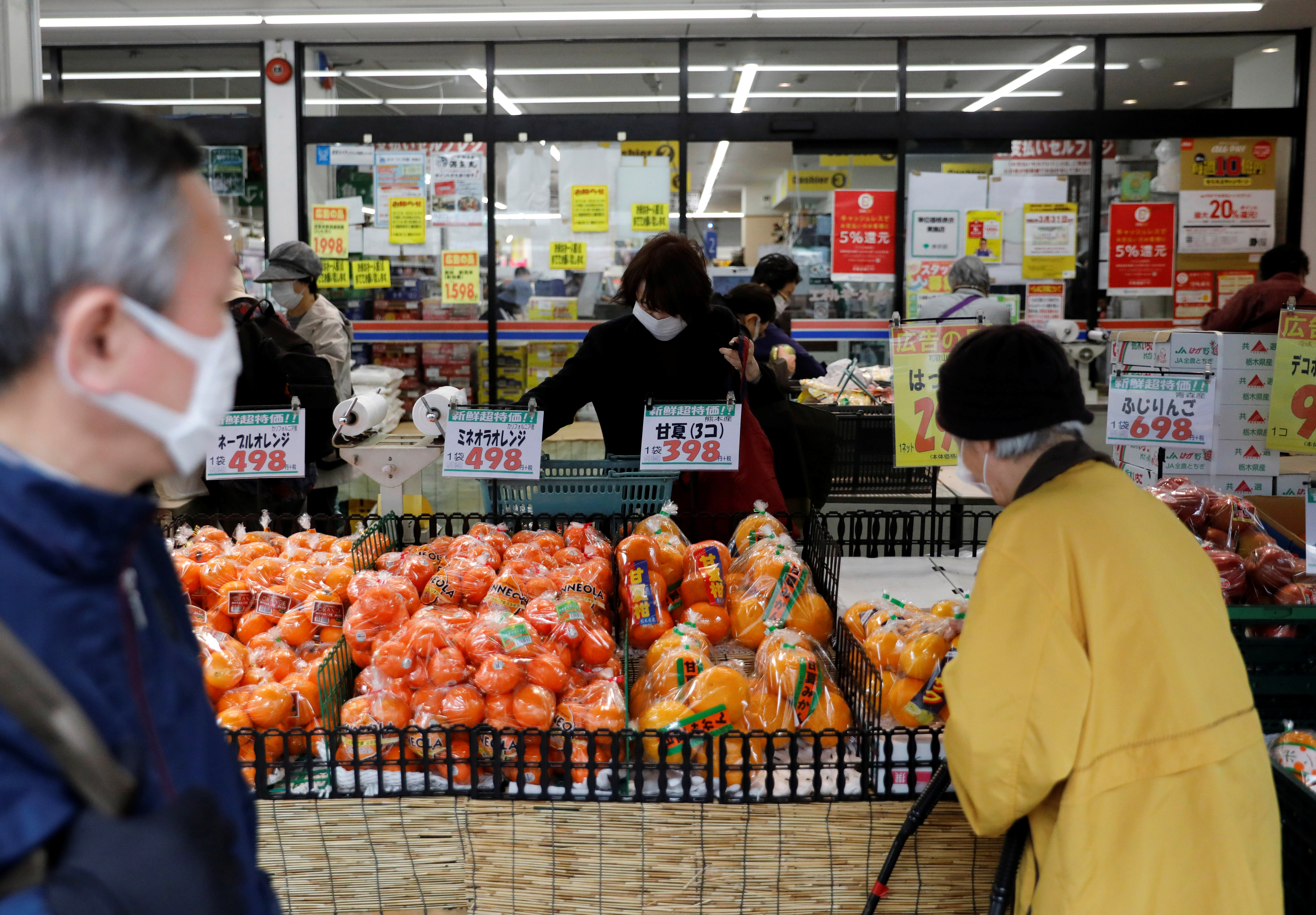 Shoppers wearing protective face masks, following an outbreak of the coronavirus disease, are seen at a supermarket in Tokyo, Japan