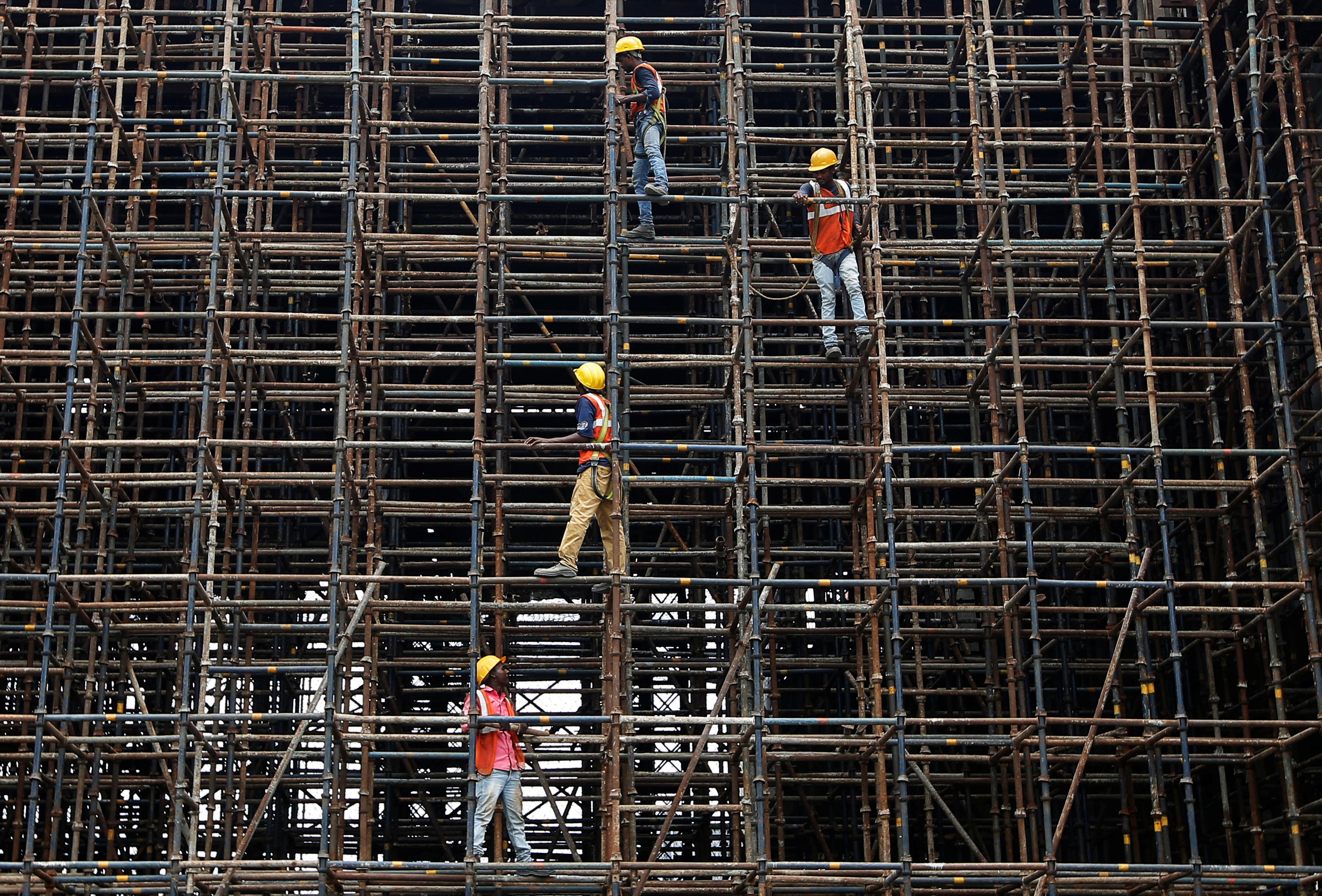 Labourers work at a construction site of a metro rail station in Kolkata