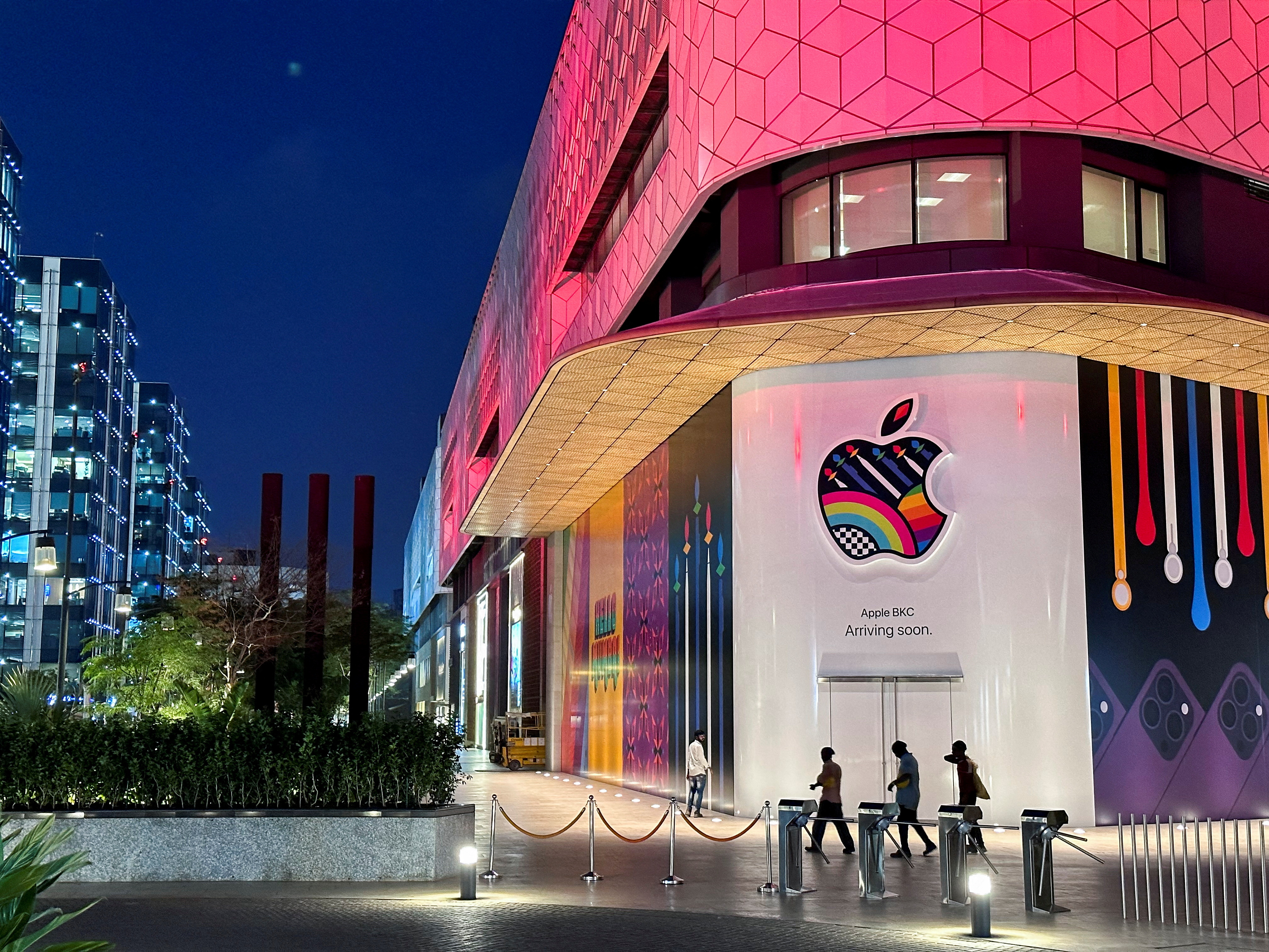 People walk past the barricade of India's first Apple retail store, that will be launched soon, in Mumbai