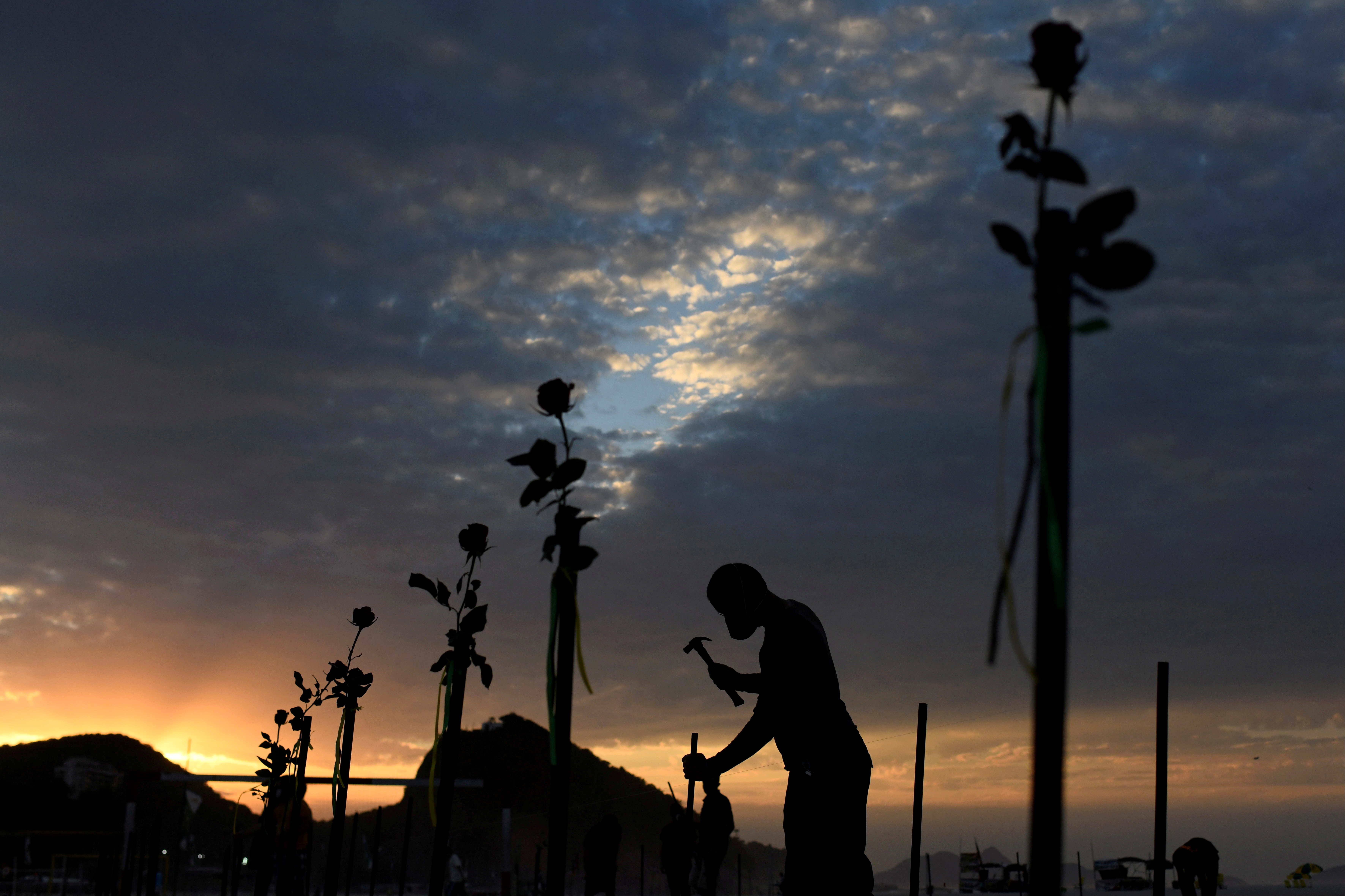 Brazilian NGO pays tribute to the country's COVID-19 victims by laying red flowers along Copacabana beach
