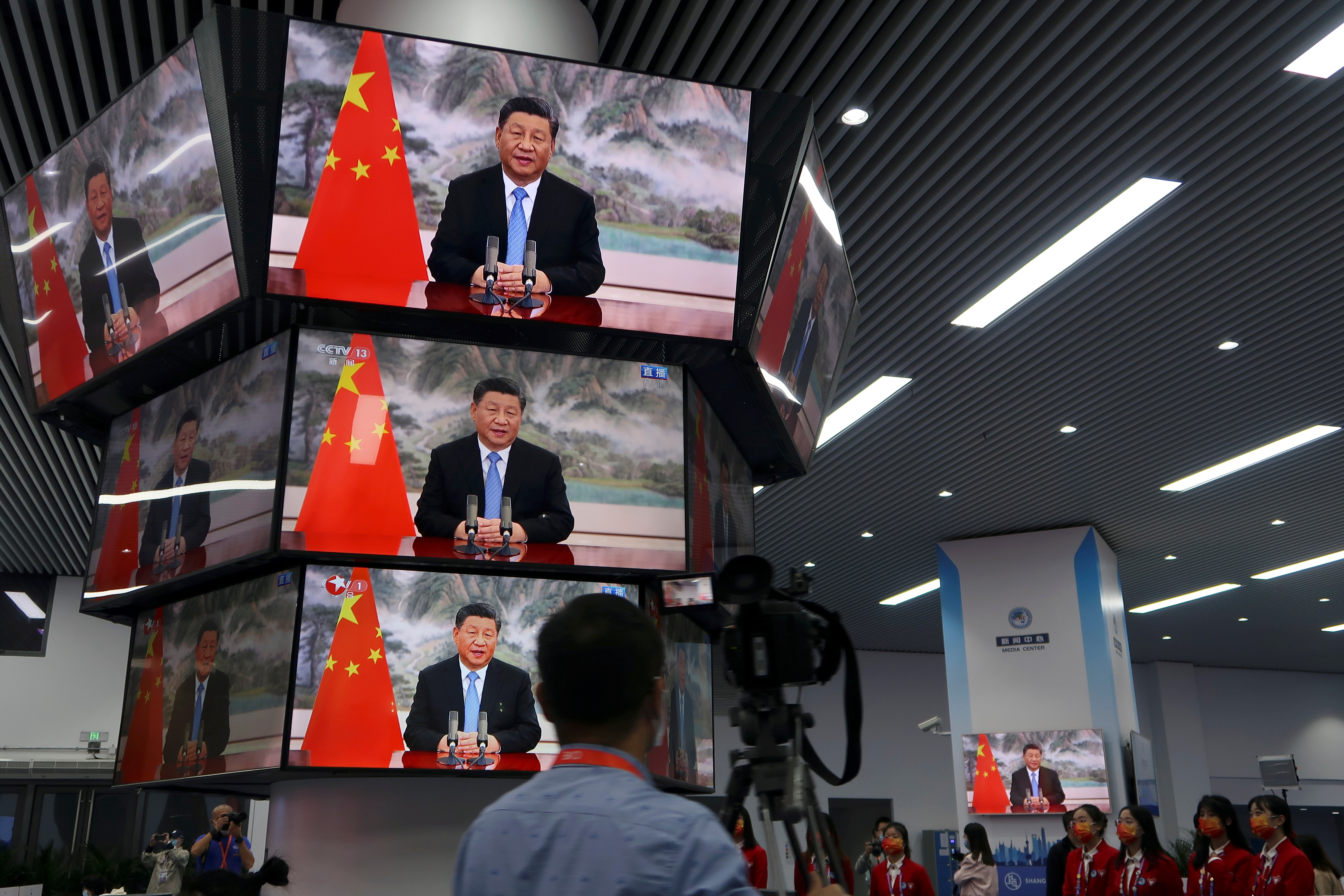 Chinese President Xi Jinping is seen on television screens at a media centre as he delivers a speech via video at the opening ceremony of the China International Import Expo (CIIE) in Shanghai, China November 4, 2021. REUTERS/Andrew Galbraith/File Photo