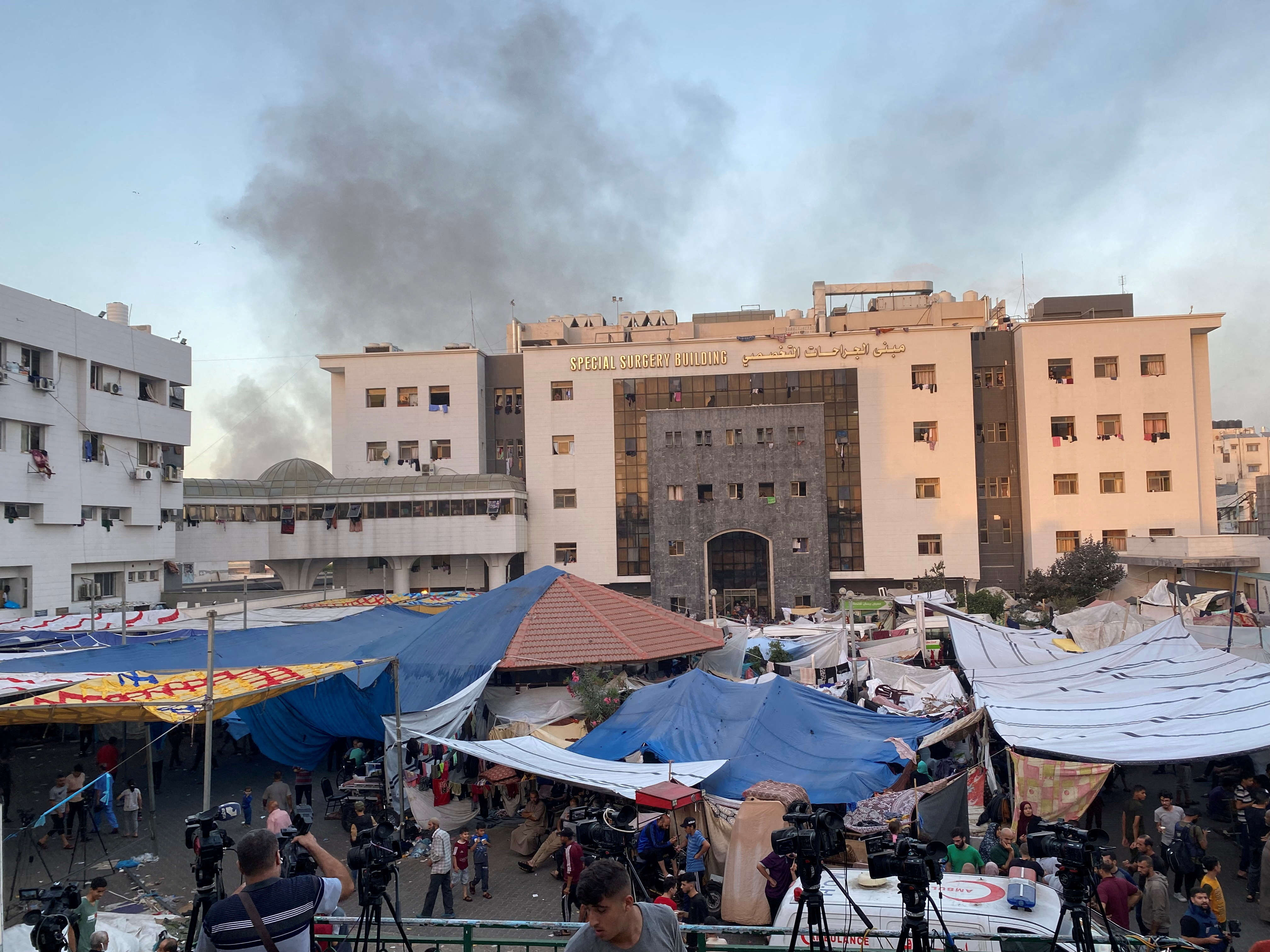 Smoke rises as displaced Palestinians take shelter at Al Shifa hospital, amid the ongoing conflict between Hamas and Israel, in Gaza City