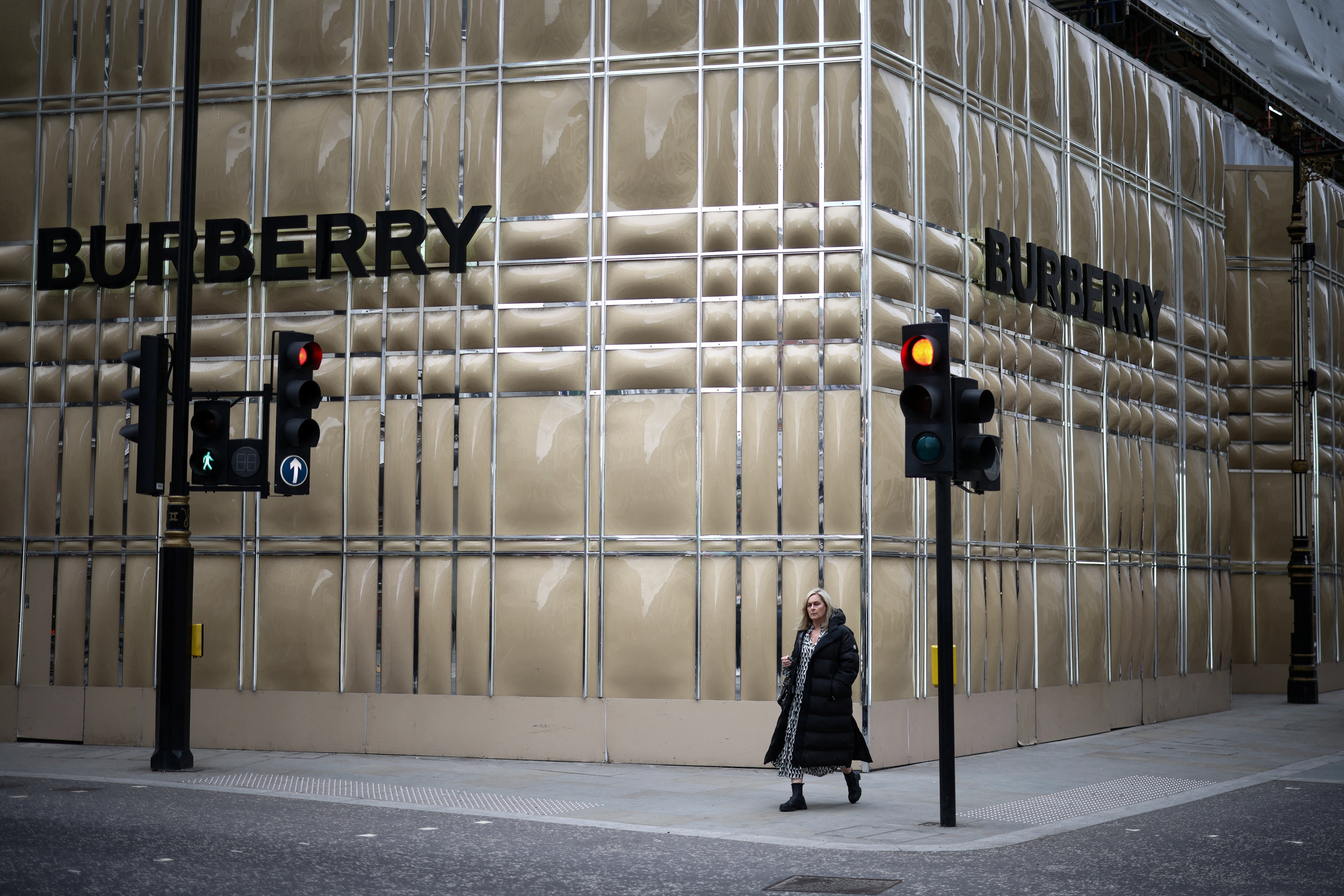 A person walks past a Burberry store undergoing refurbishment on New Bond Street in London