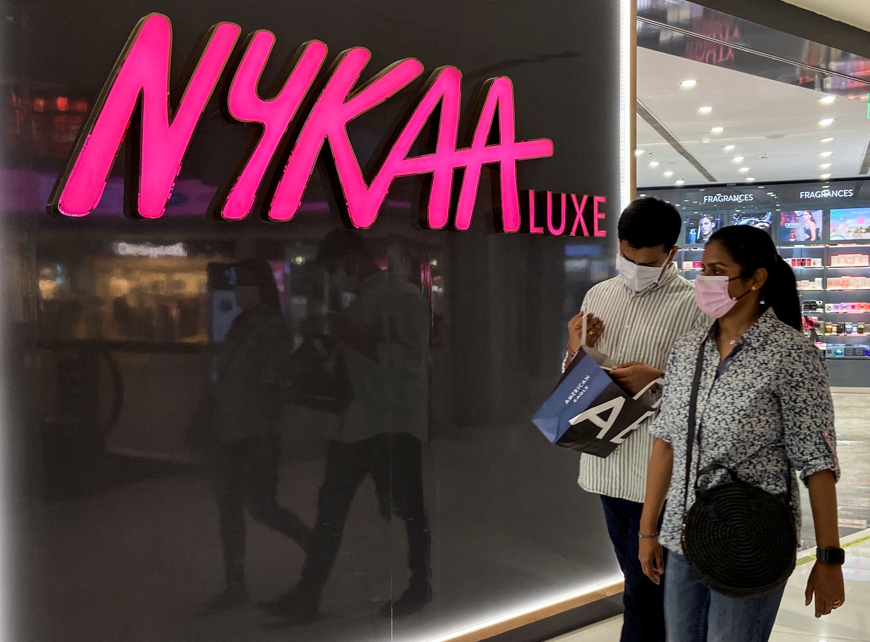 People walk past a store of Nykaa, an Indian beauty products retailer, at a mall in New Delhi