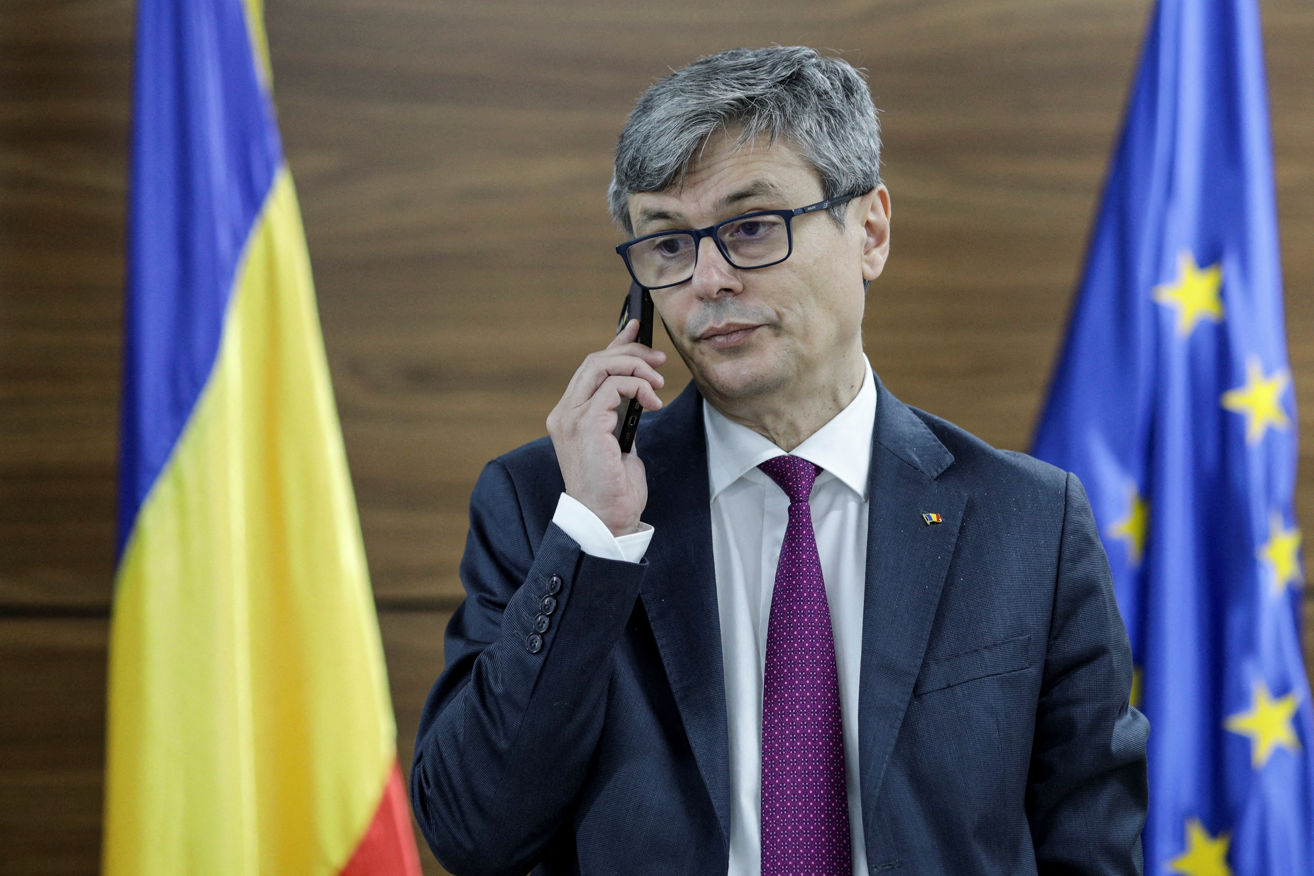 Romanian Energy Minister, Virgil Popescu, talks on the phone before an interview with Reuters