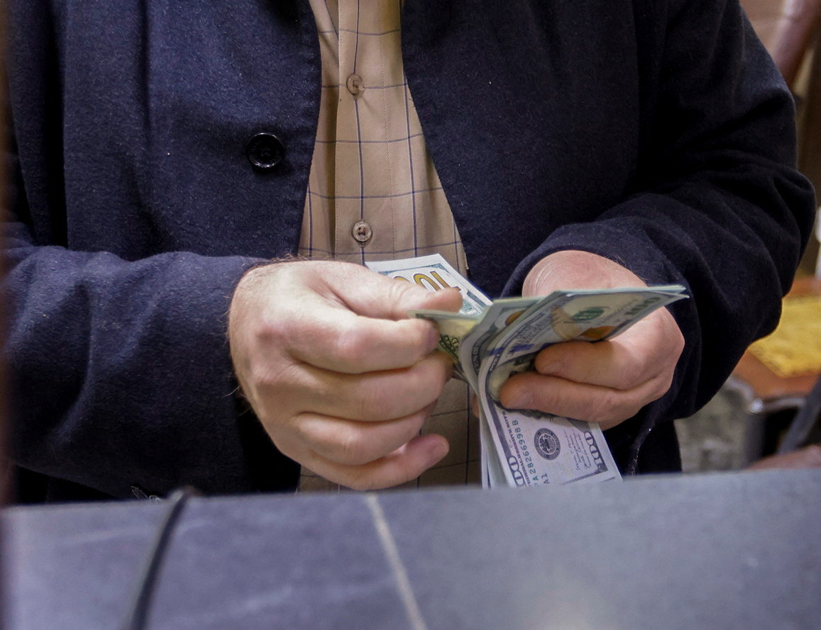 A man counts U.S. dollars at a currency exchange shop in Baghdad