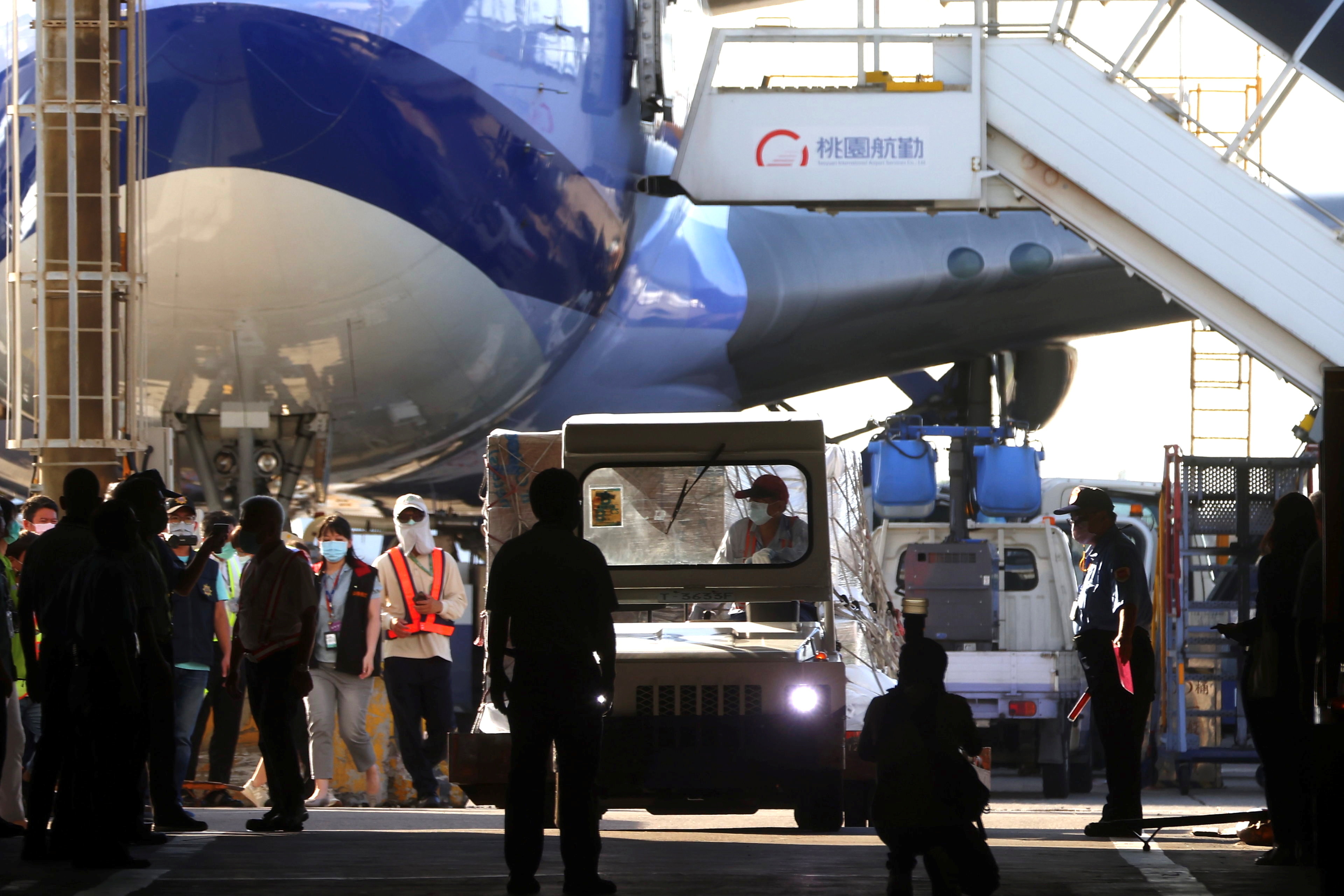 Workers transport Moderna vaccines against the coronavirus disease (COVID-19) to Taiwan Air cargo Terminal in Taoyuan