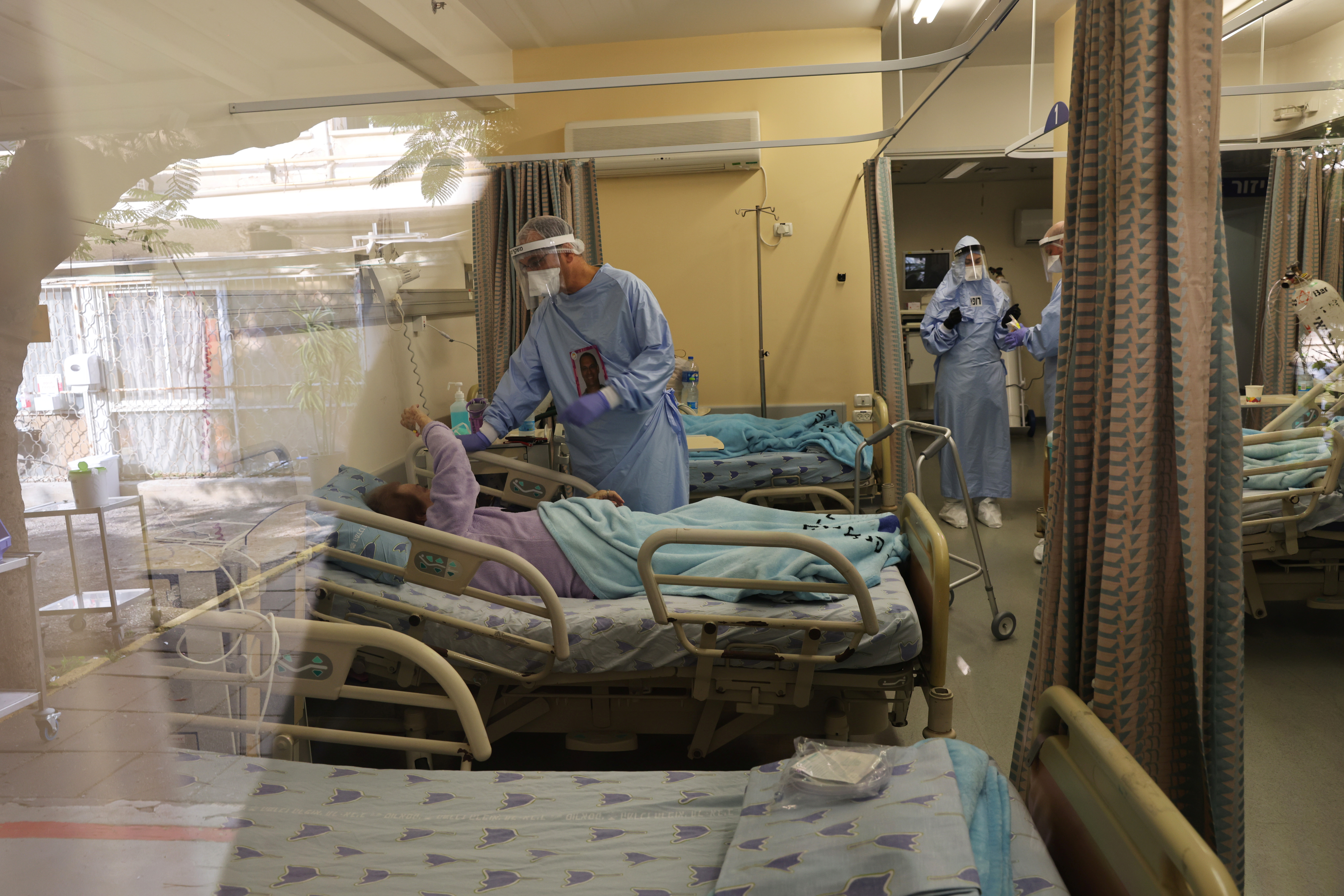 Doctor Guy Choshen, director of the COVID-19 ward in Ichilov Hospital, speaks to a patient in Tel Aviv