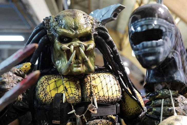 An attendee, dressed as The Predator, their favourite movie character, poses for photographs during the Leisure and Fantasy Lounge "SOFA" in Bogota