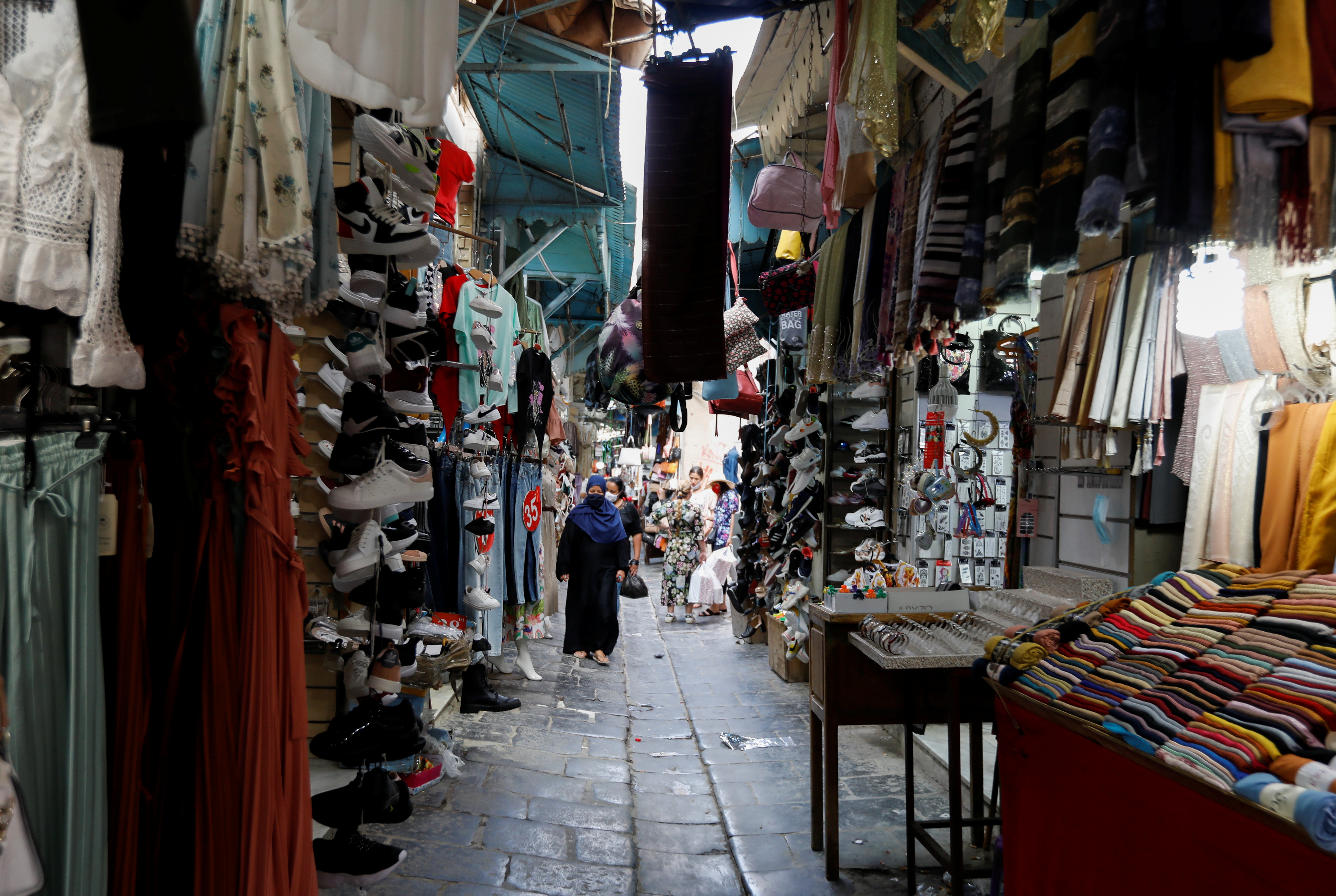 People walk past shops in the Medina, in the old city of Tunis