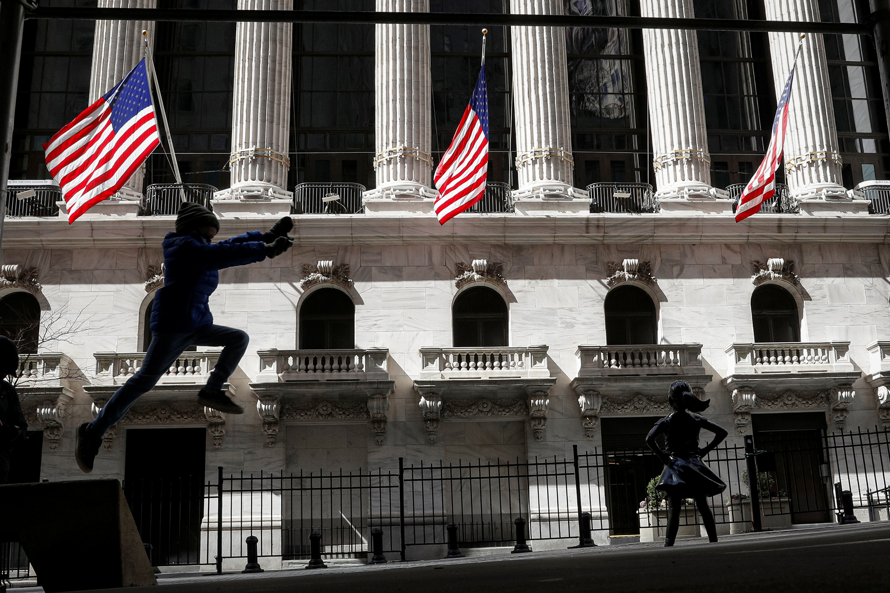 A child leaps off a bench outside the NYSE in New York