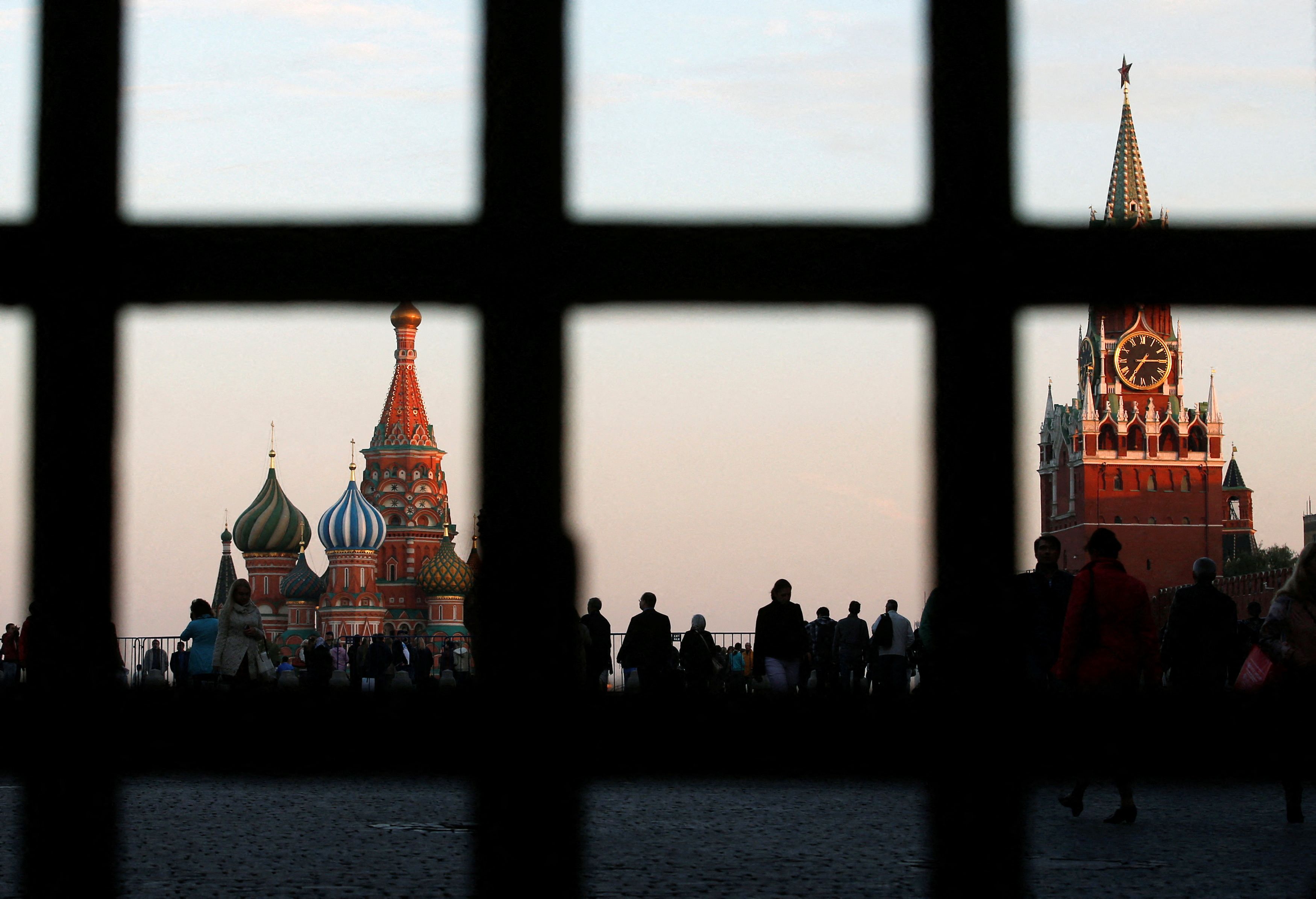 Red Square, St. Basil's Cathedral and the Spasskaya Tower of the Kremlin are seen through a gate in central Moscow