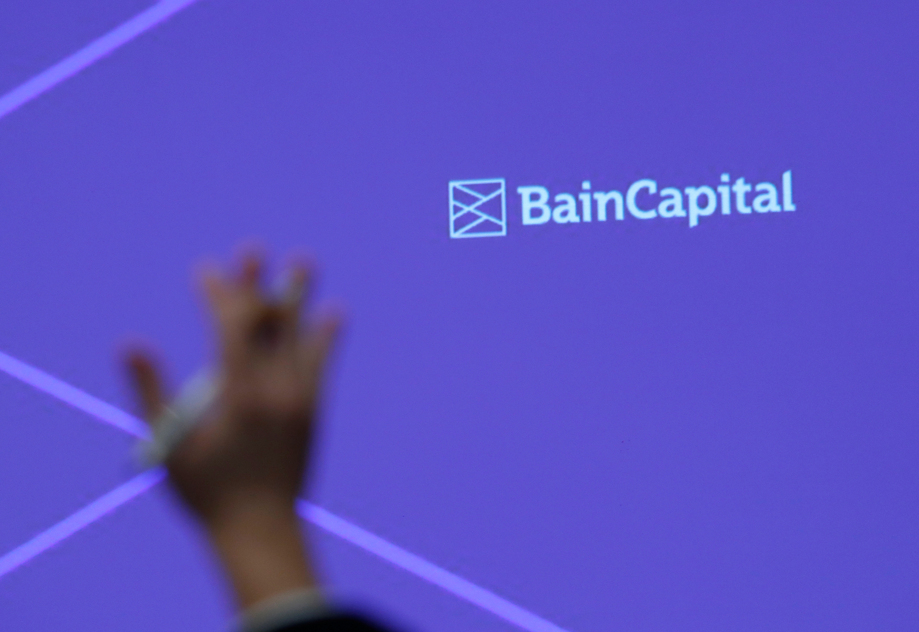 A reporter raises his hand to ask a question during a news conference by Bain Capital LP Managing Director Sugimoto in Tokyo