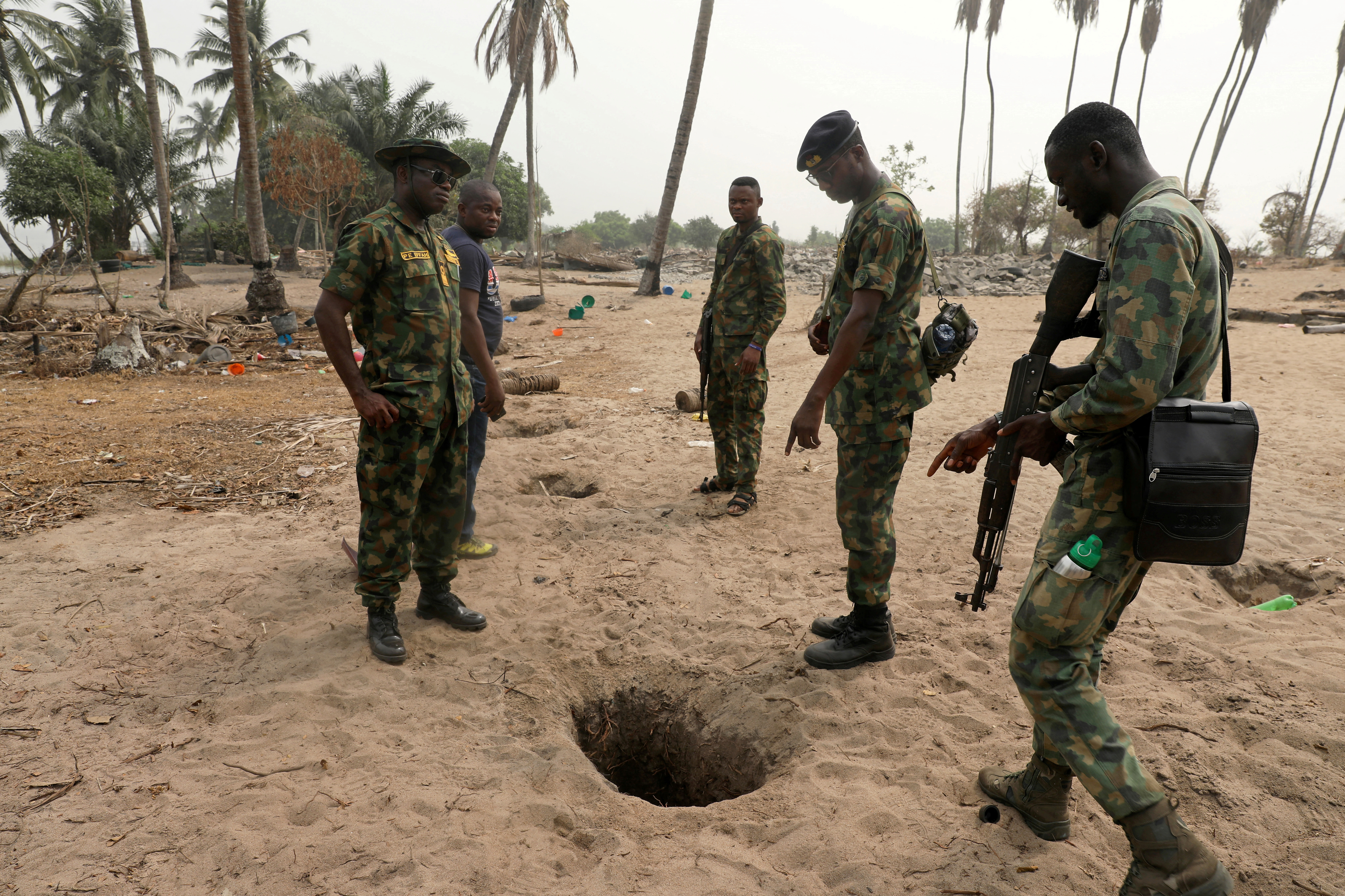 Naval officers inspect an illegally-dug oil well at ilashe in Lagos