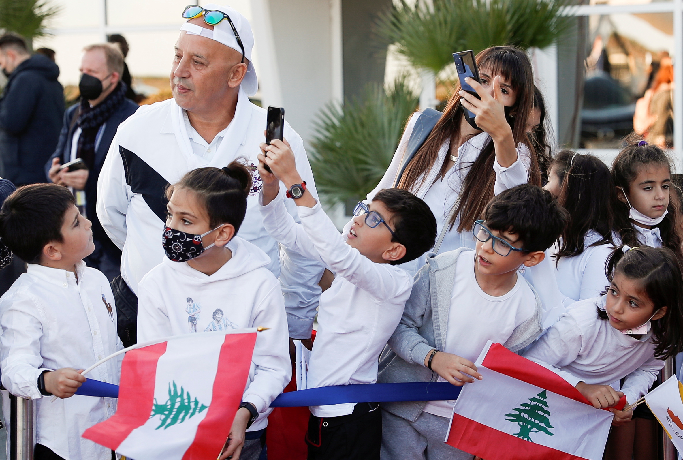 Children holding flags of Lebanon wait for Pope Francis at the Larnaca International Airport as he arrives for his visit to Cyprus and Greece, in Larnaca, Cyprus, December 2, 2021. REUTERS/Guglielmo Mangiapane